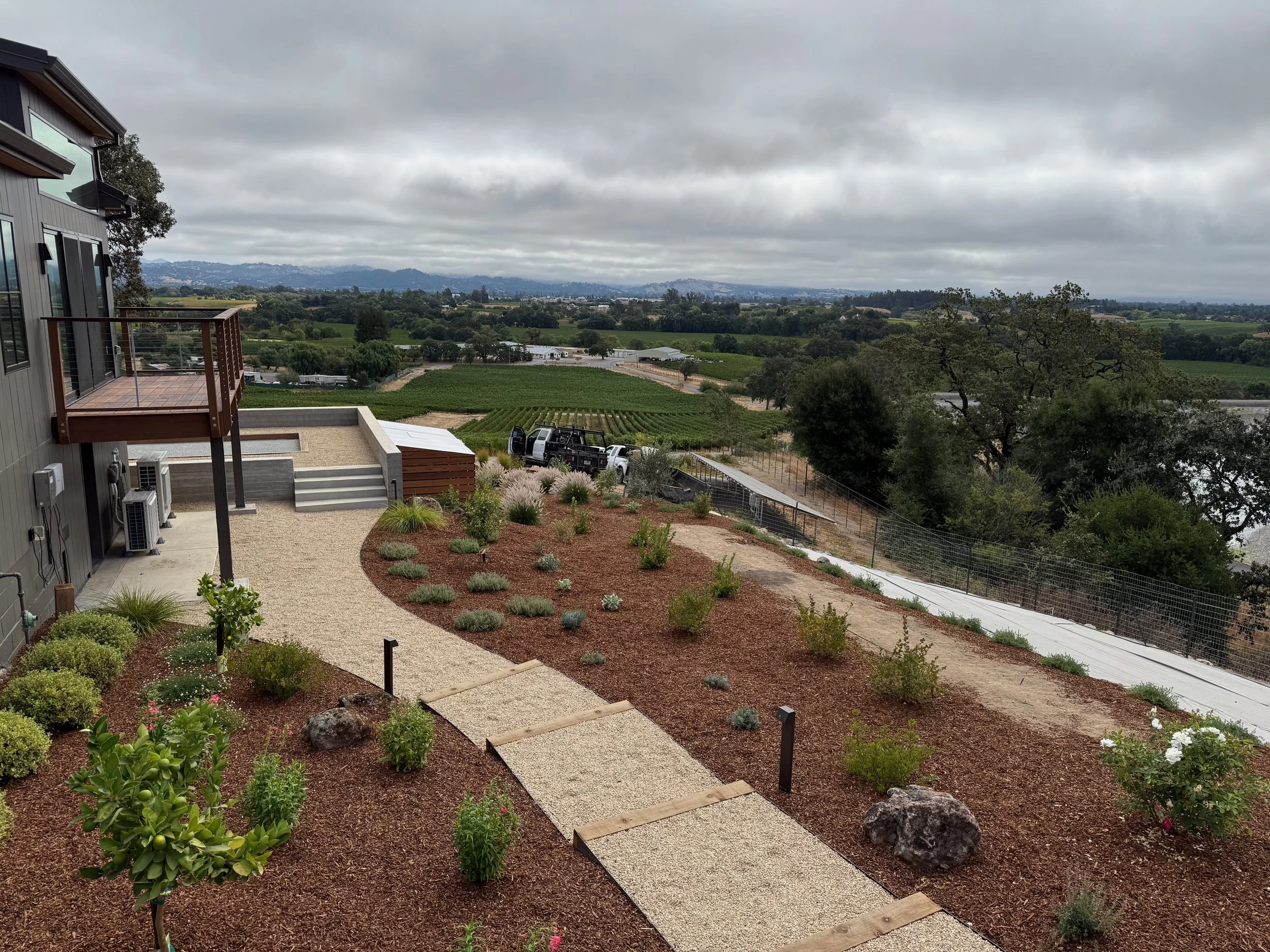 Gravel walkway with surrounding edible garden and outdoor path lighting.