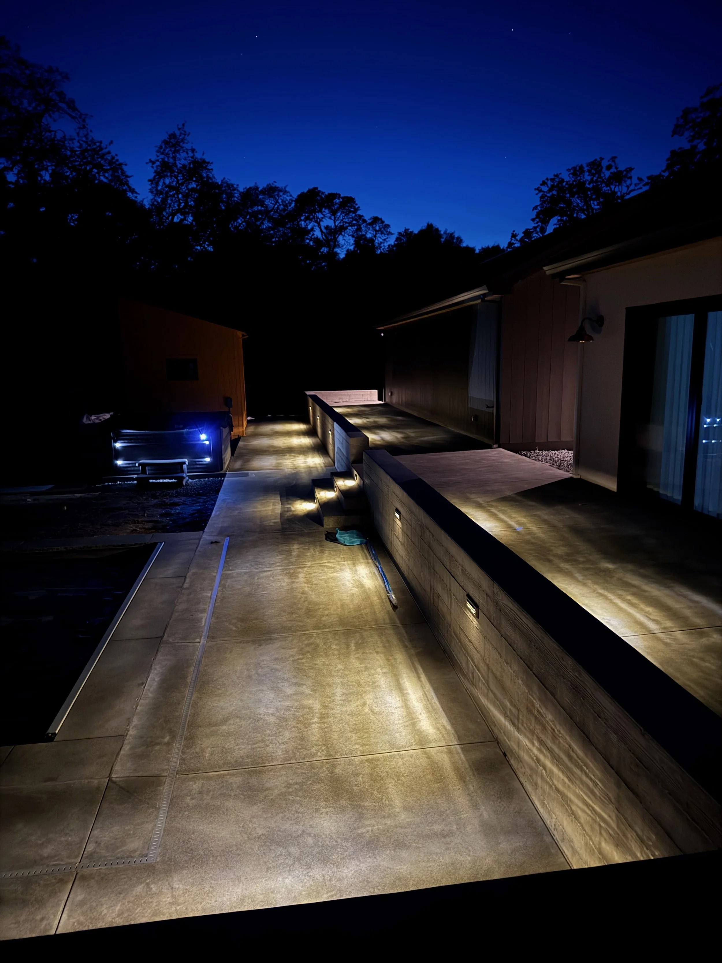Form poured retaining wall and patio with step light and wall lights