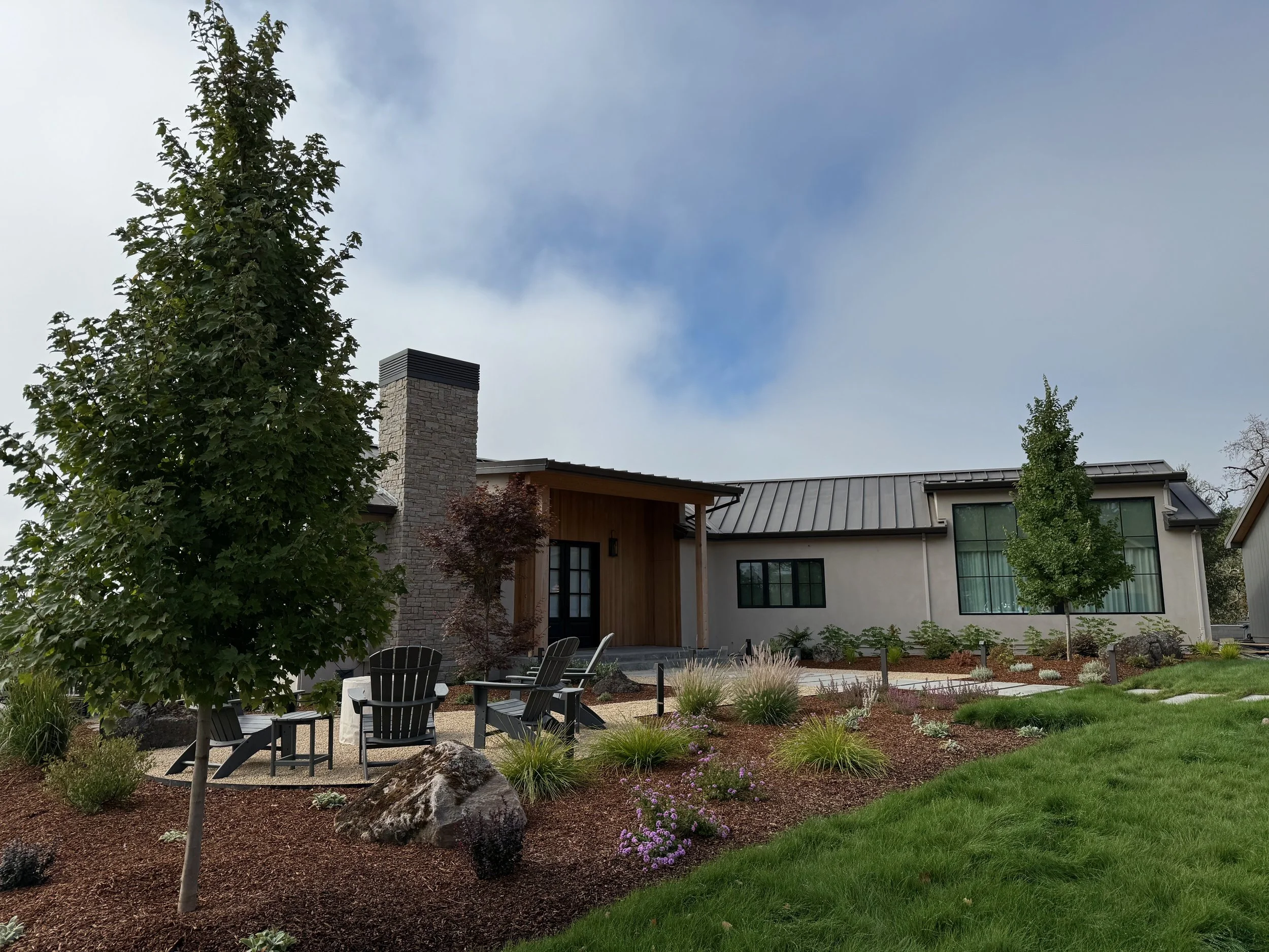 Native front yard landscape with Native Preservation grass, gravel fire pit patio, natural boulders, and modern landscaping in Windsor, CA.