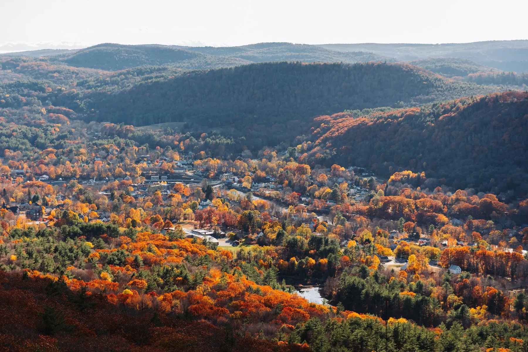 Panoramic view of colorful autumn forests, rolling hills, and a village in Western Massachusetts.
