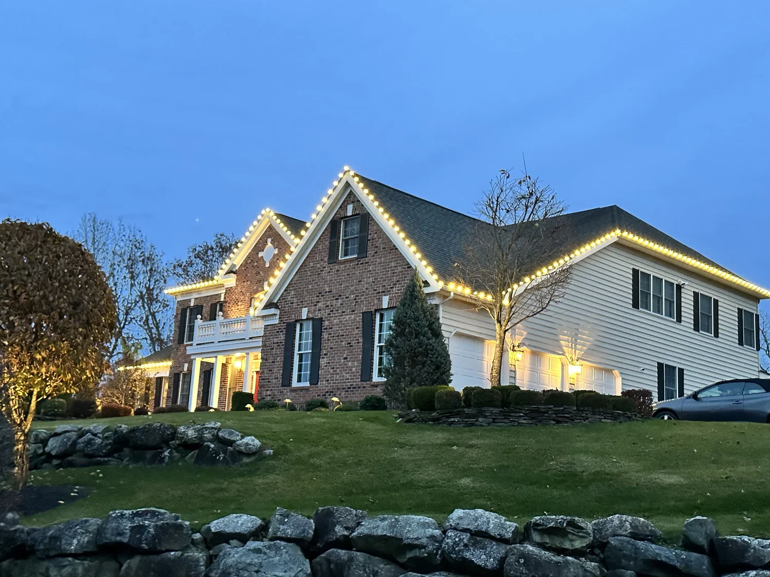 Warm white lights tracing a residential roofline