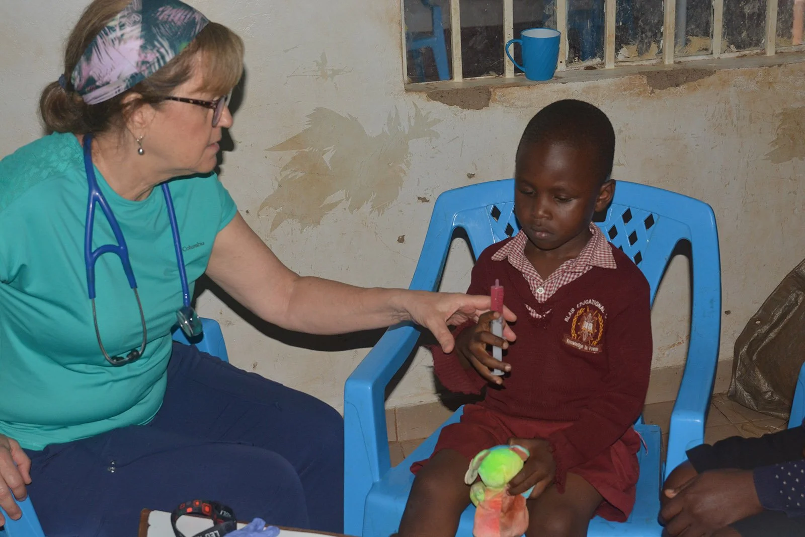 A nurse helps a child take oral medicine