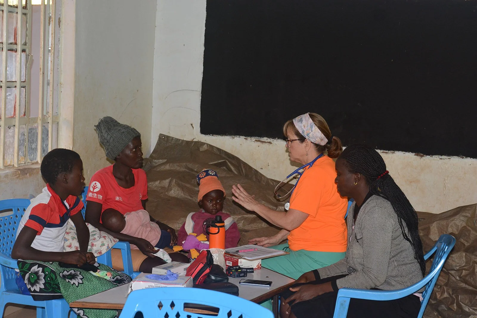 A nurse sits with a family at the medical clinic