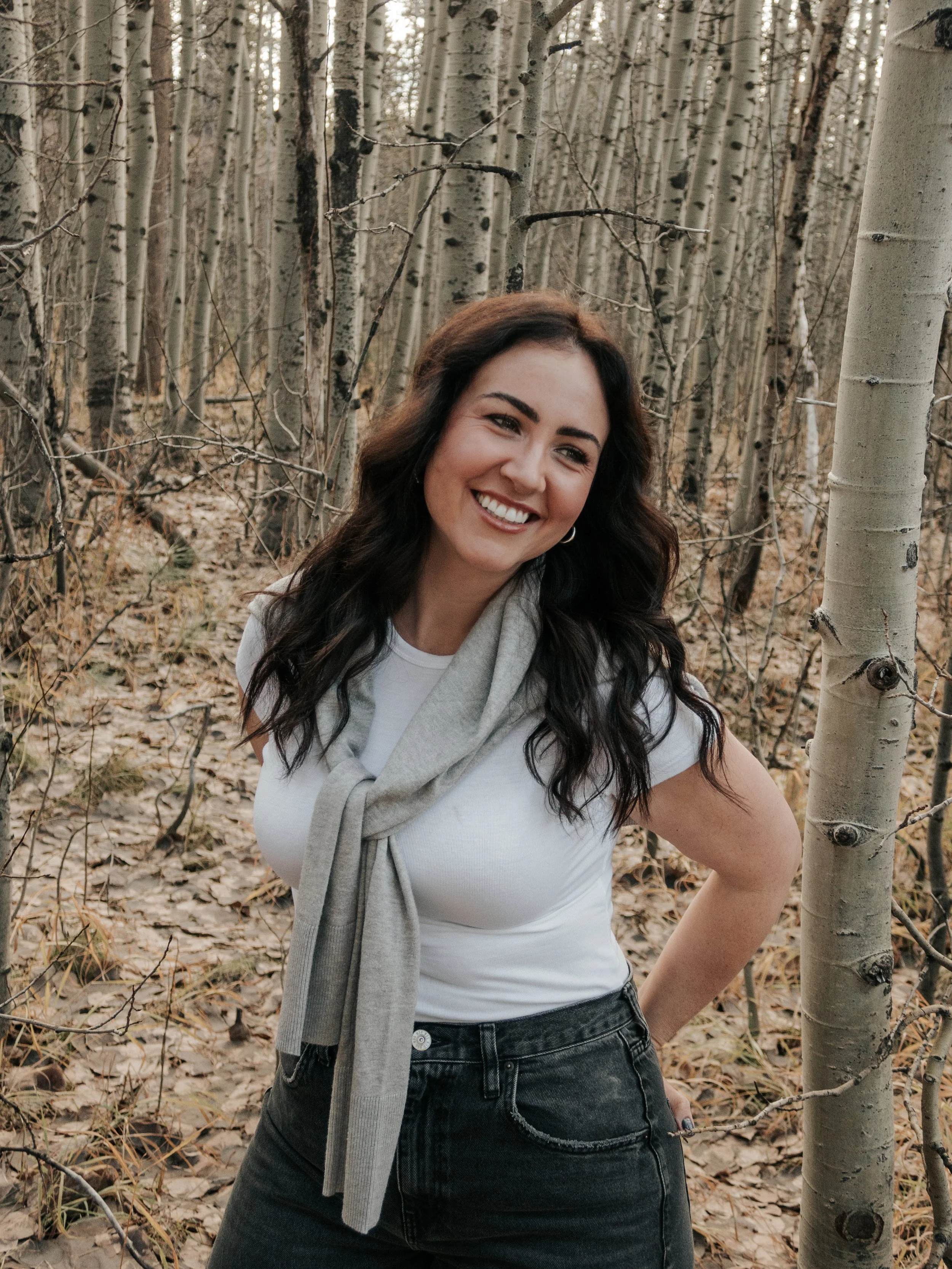 Cady, a Solano County photographer, standing among trees in a pink Photos by Cady frame.