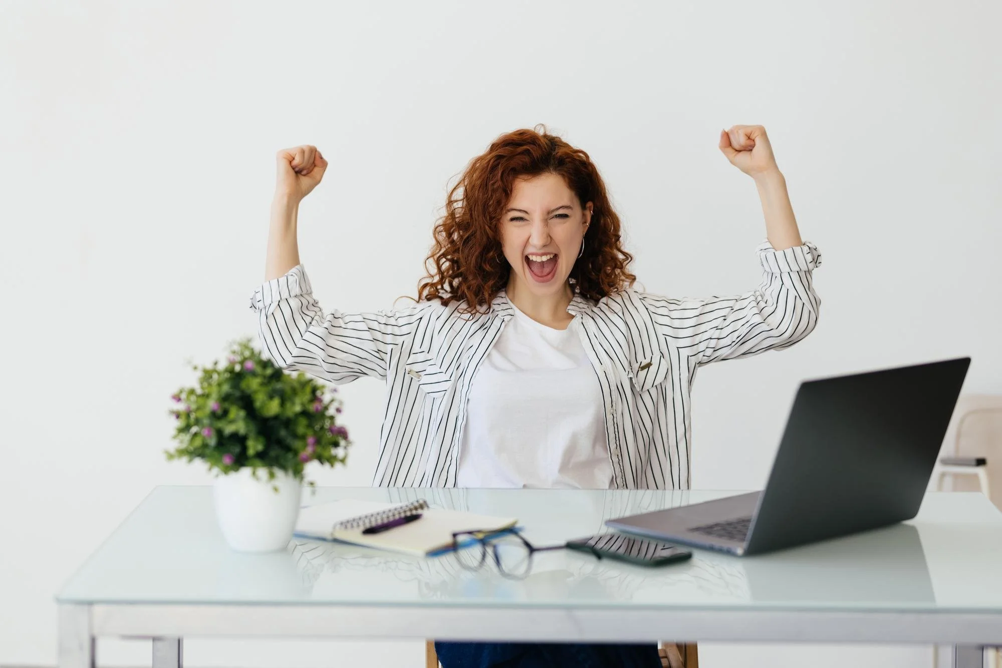 young-redhead-curly-woman-working-with-her-laptop-raising-fist-after-victory-winner-concept.jpg
