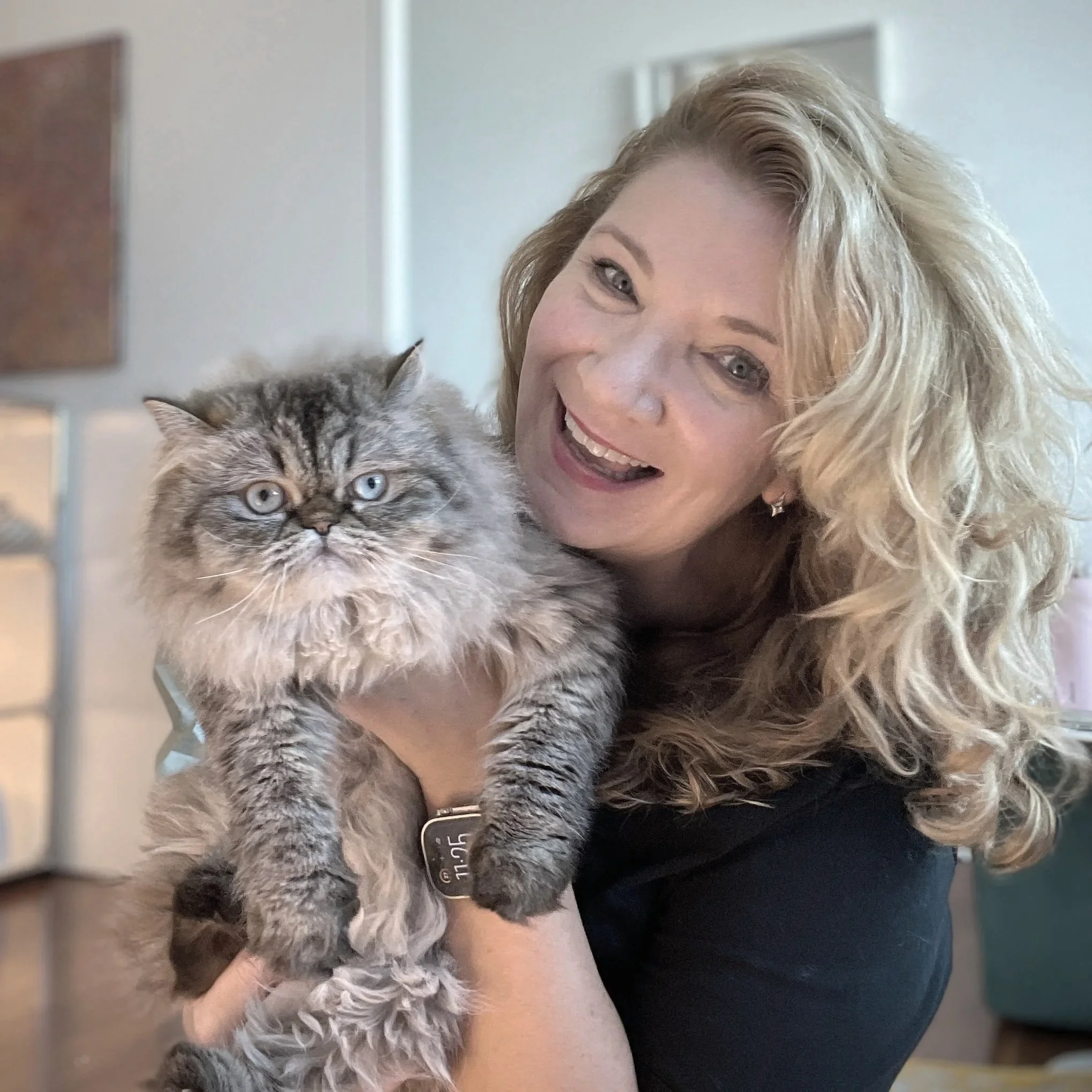Photo of artist and illustrator Aly Indermühle holding her cat Maddie, one of her two studio assistants.