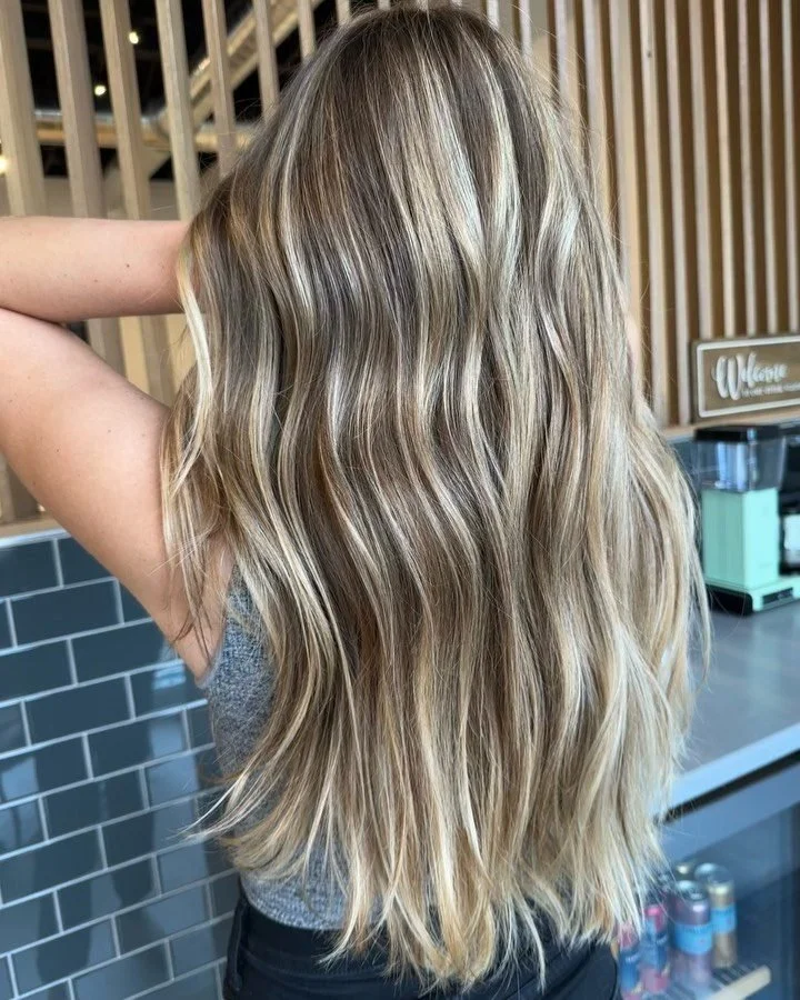 Long lived-in balayage with soft blonde ribbons at Grand Noir Salon in Verona, WI