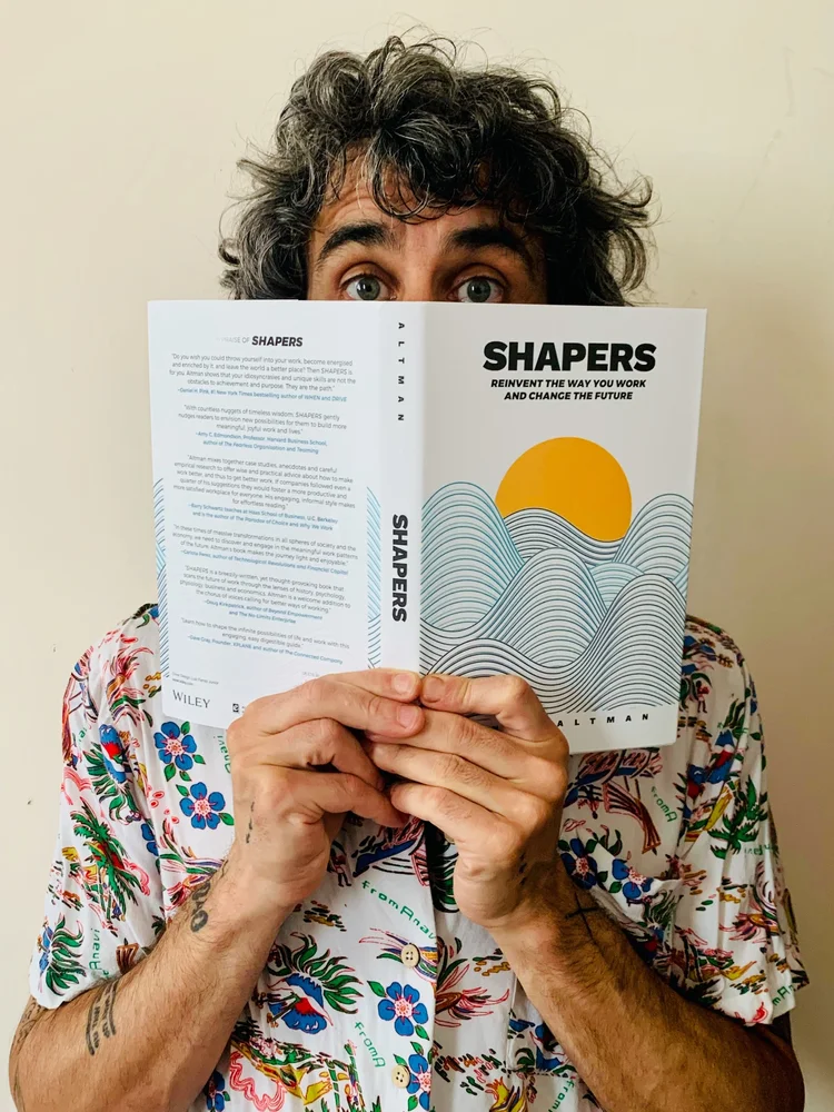 A reader holding Shapers by Jonas Altman