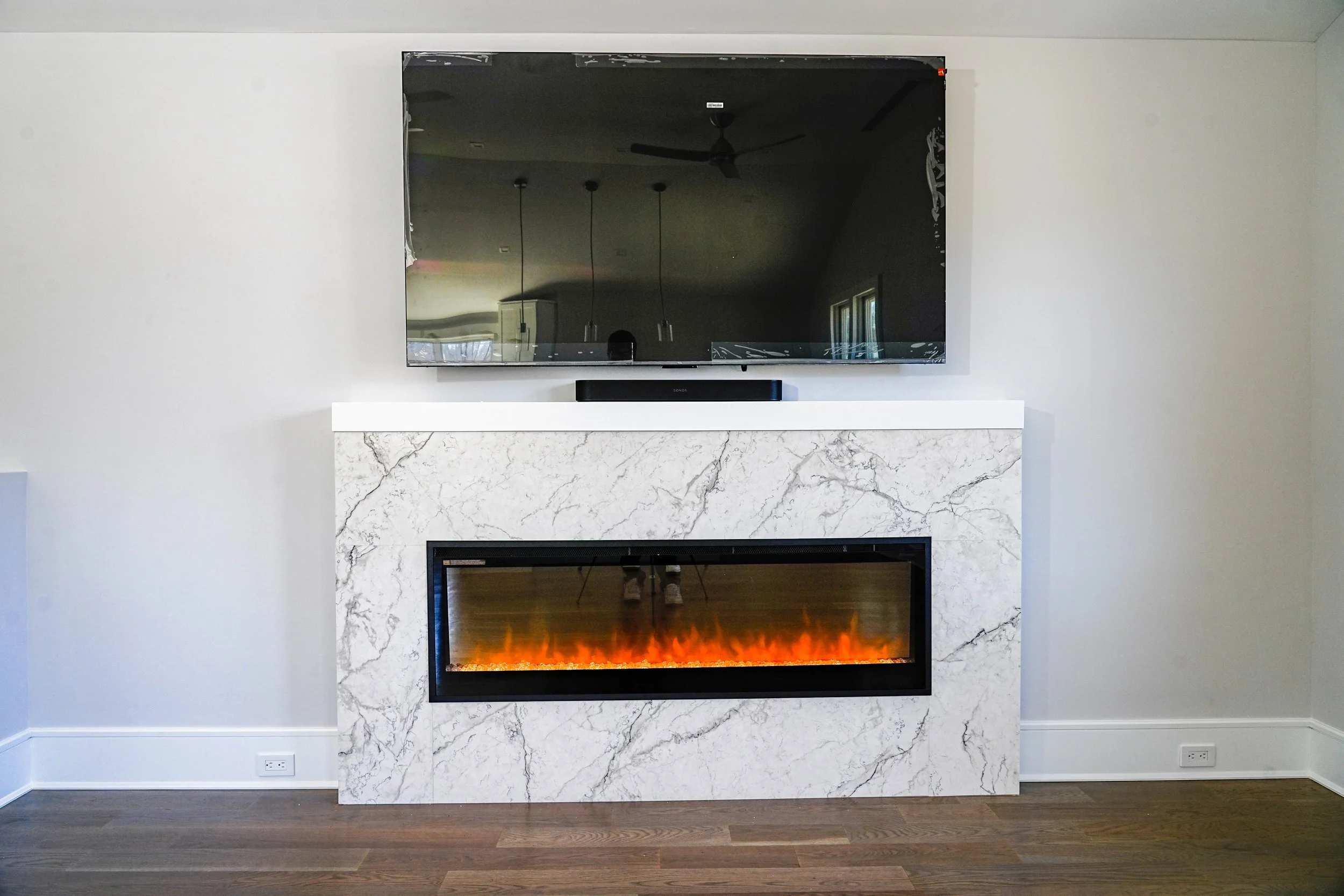 Custom marble fireplace with an integrated electric fire by C. Staker Remodeling