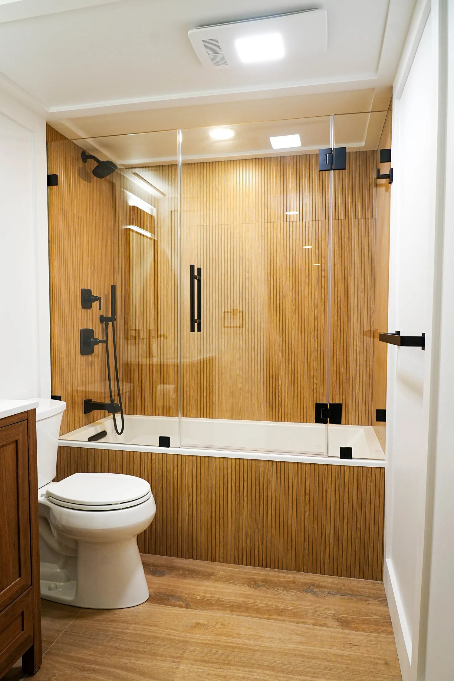 Wood-Tone Bathroom & Glass Shower — photograph 2