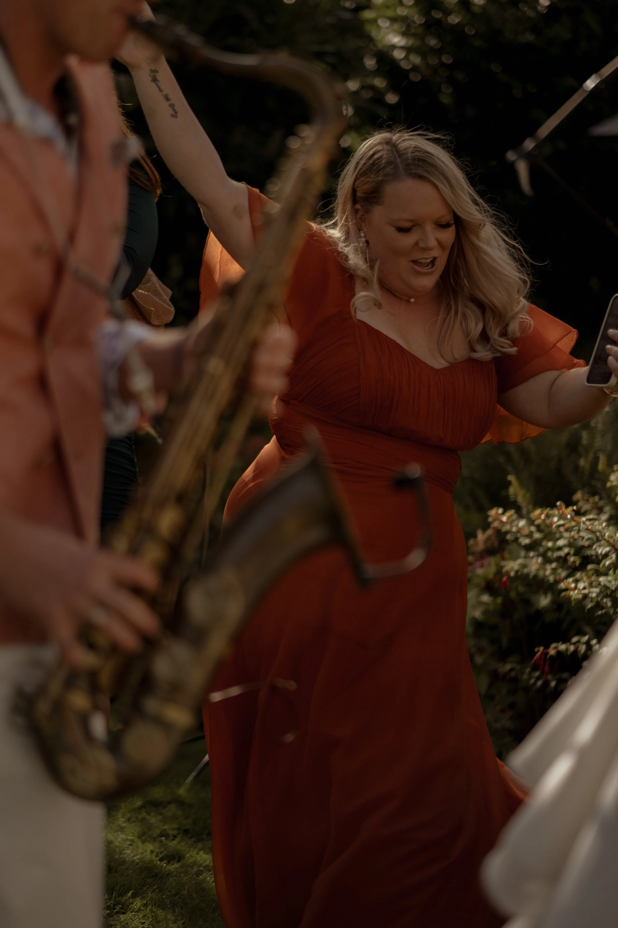 Natural Wedding photography moment, capturing a wedding guest dancing with a saxophonist at Glewstone Court, Ross on Wye
