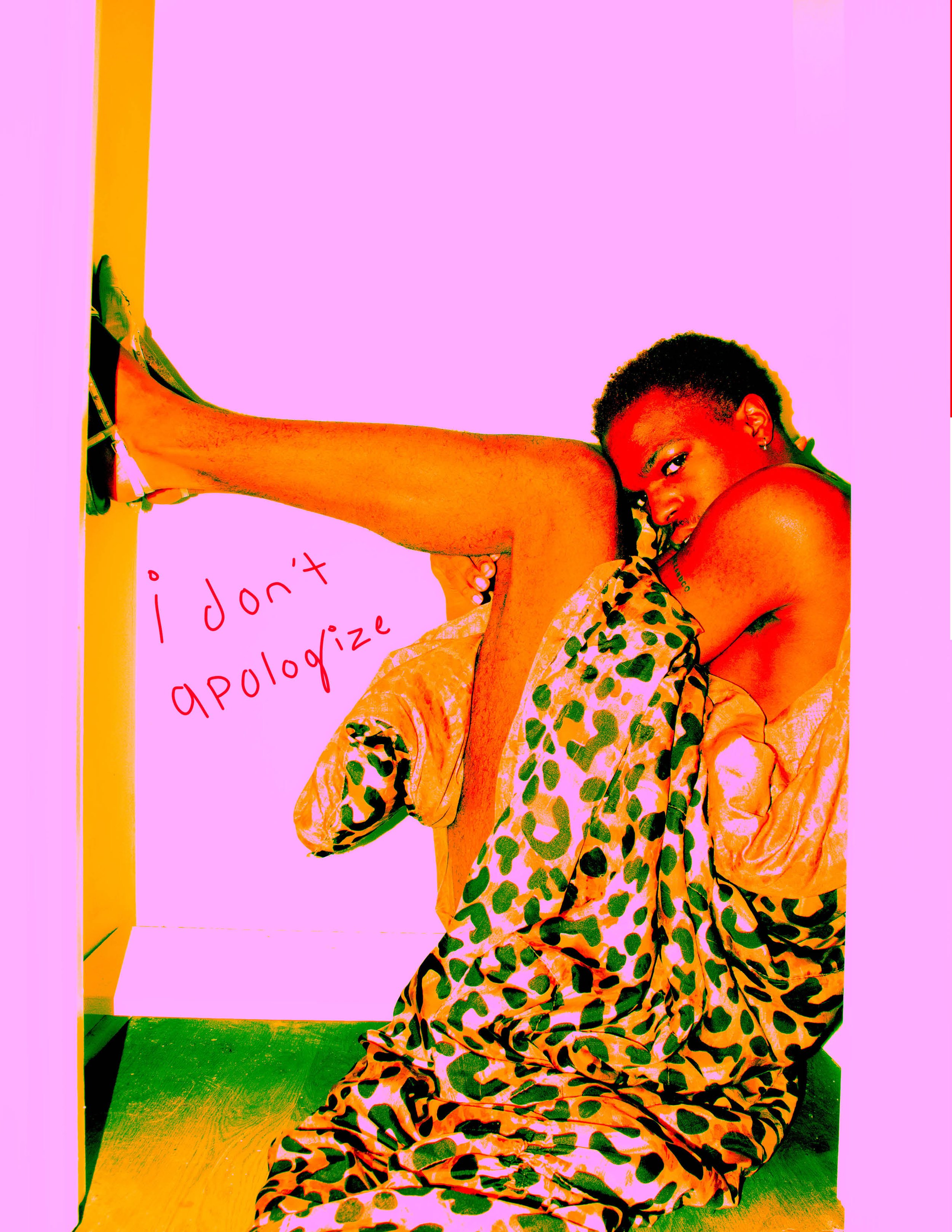 A person with short curly hair wearing leopard print clothing, sitting on the floor with one leg raised and bent, resting their head on their knee, against a pink background. The words 'i don't apologize' are written in red next to them.