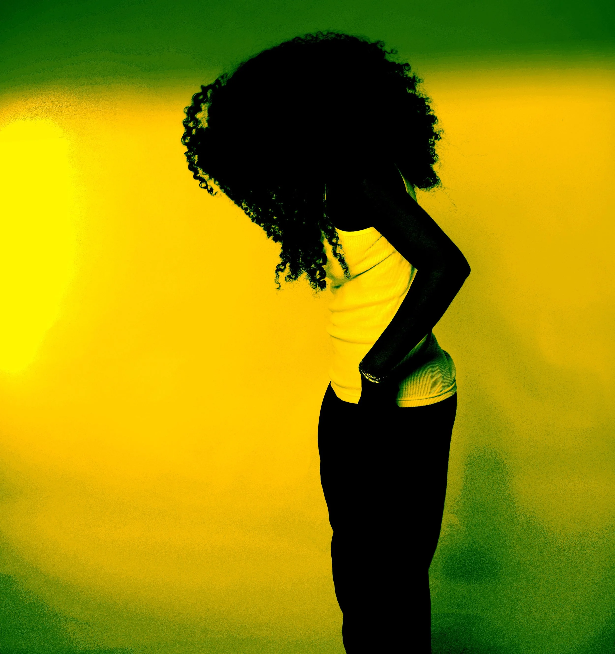 Silhouette of a woman with curly hair standing against a vibrant yellow and green background, looking downward with hands on her hips.