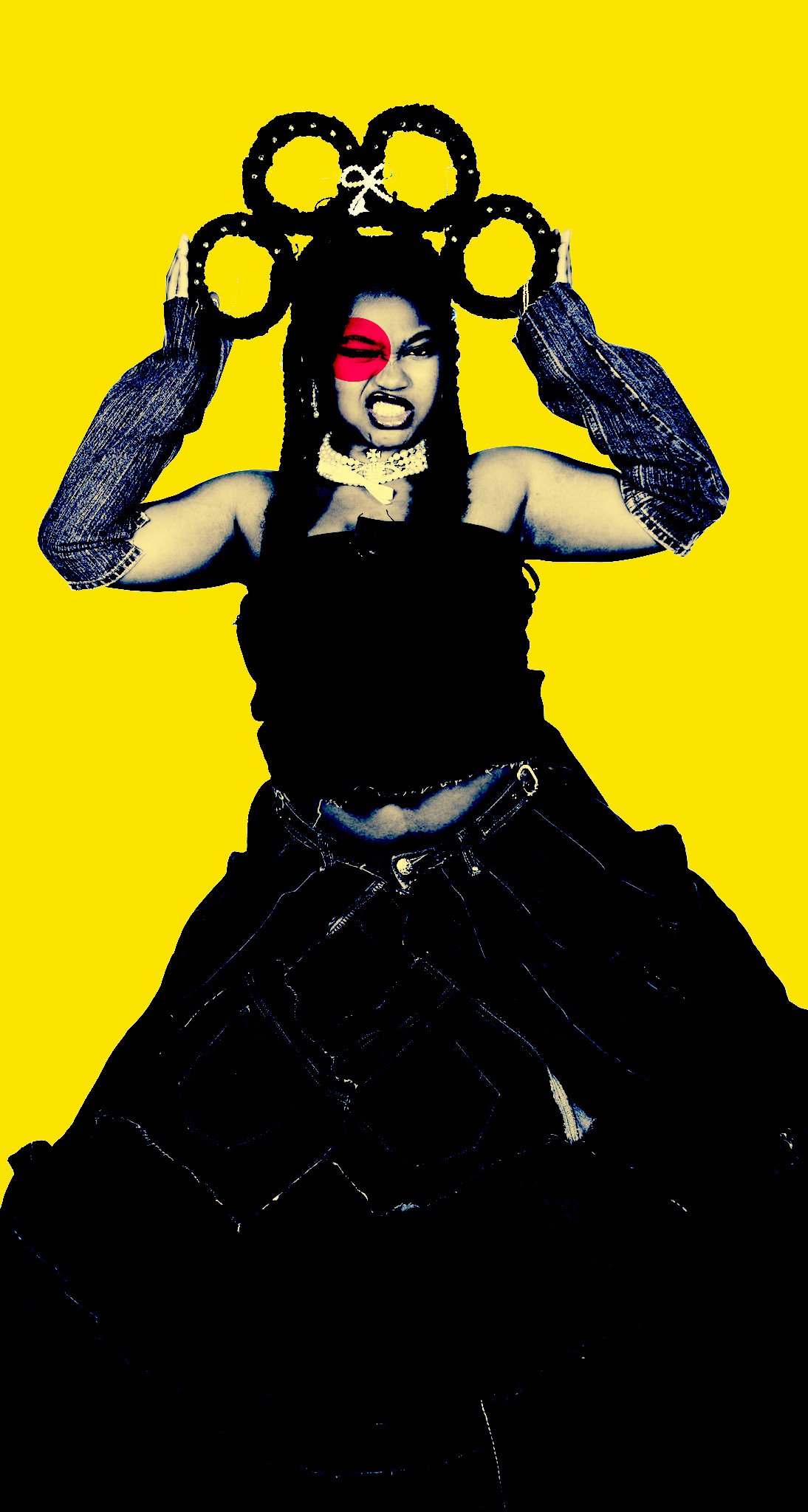 A woman with dark hair styled in dreadlocks, wearing a red eye patch, making an angry face, holding large black rings above her head, against a bright yellow background.