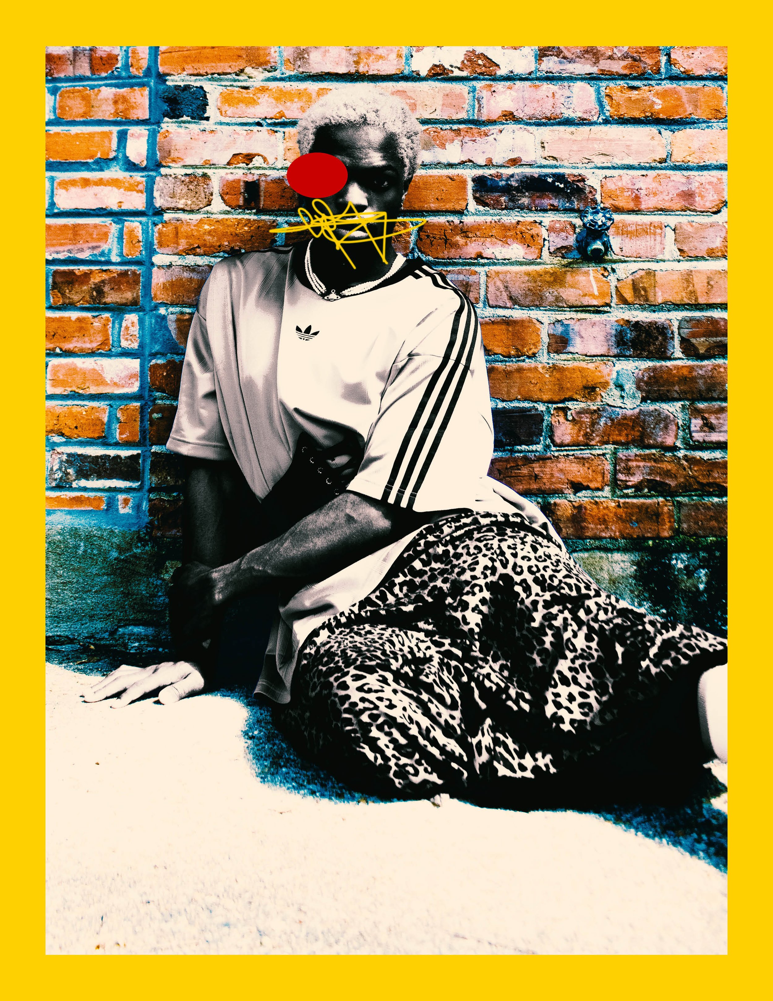 An image of a person sitting against a brick wall with added digital doodles on their face, including a red circle, yellow squiggly lines, and other abstract markings, wearing a sports jersey and leopard print shorts.