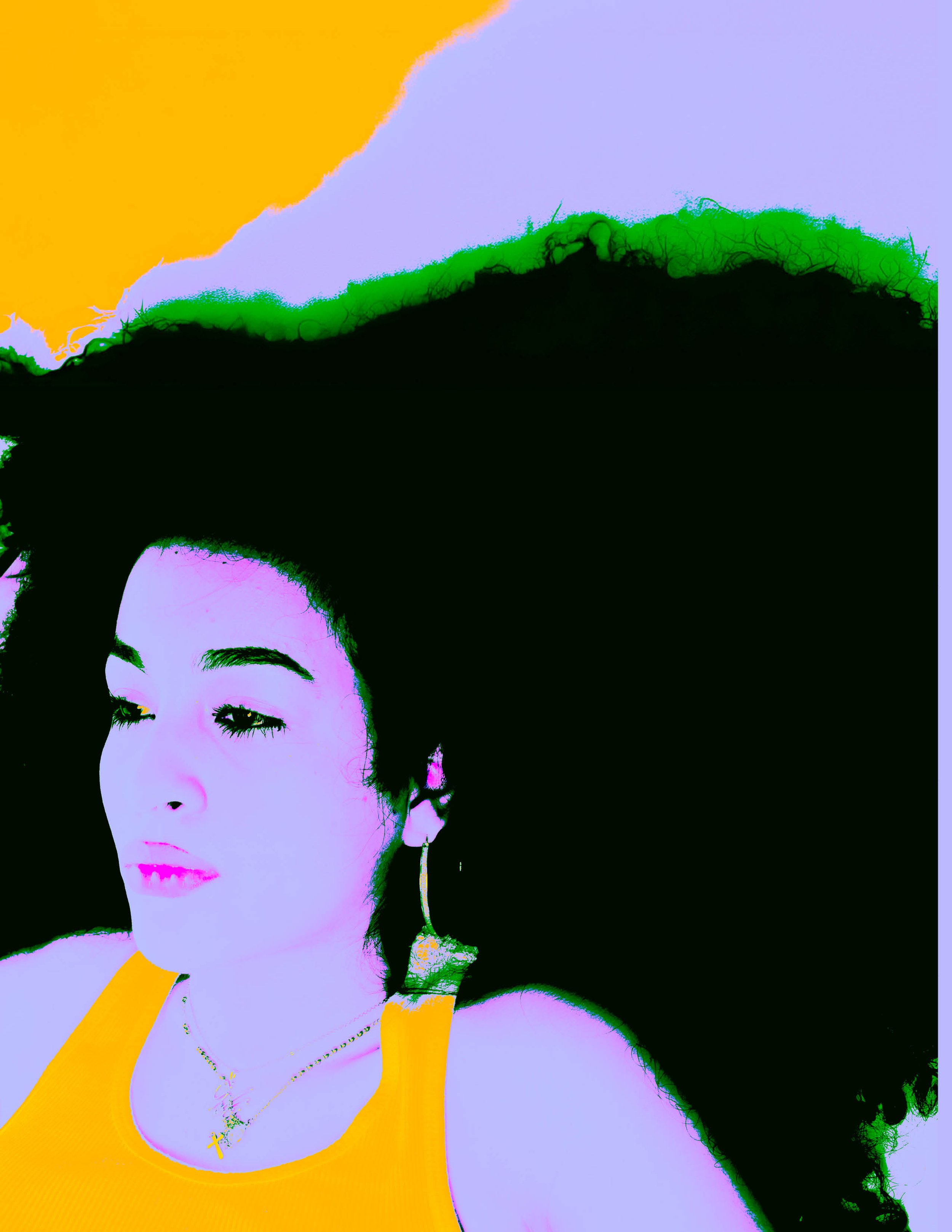 A woman with dark curly hair wearing a gold hoop earring, a gold cross necklace, and a yellow sleeveless top, lying on a black surface with a colorful, abstract background.