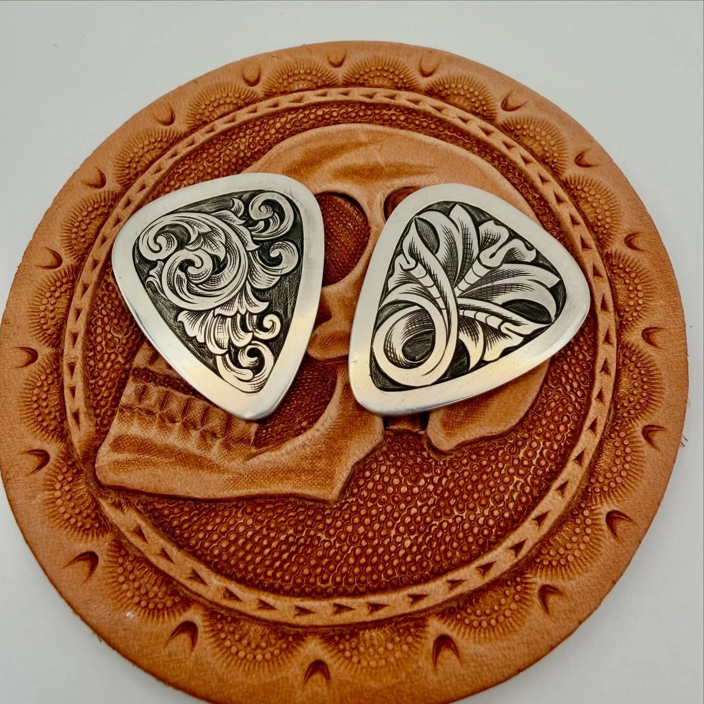 Another handful of sterling guitar picks out the door. I&rsquo;ve been using these as an opportunity to practice sketching directly on the silver and worry less about composition than I typically do. Holler if you want one! #engraving #handengraving 