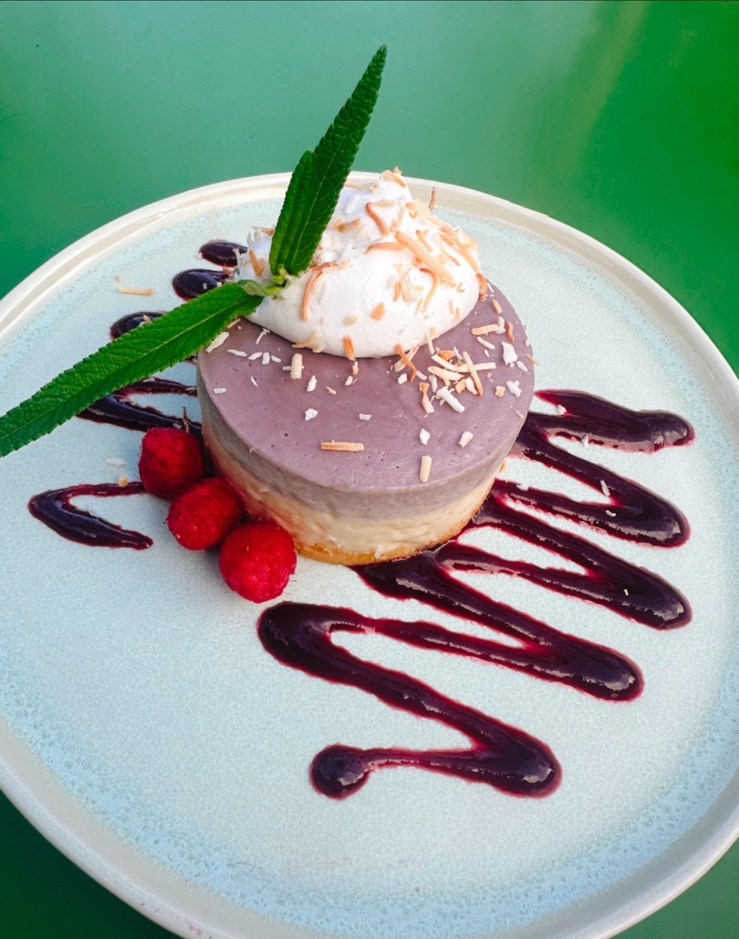 Indulge in our new vegan berry cashew cheesecake served with coconut cream, toasted coconut and berry coulis. 🥥