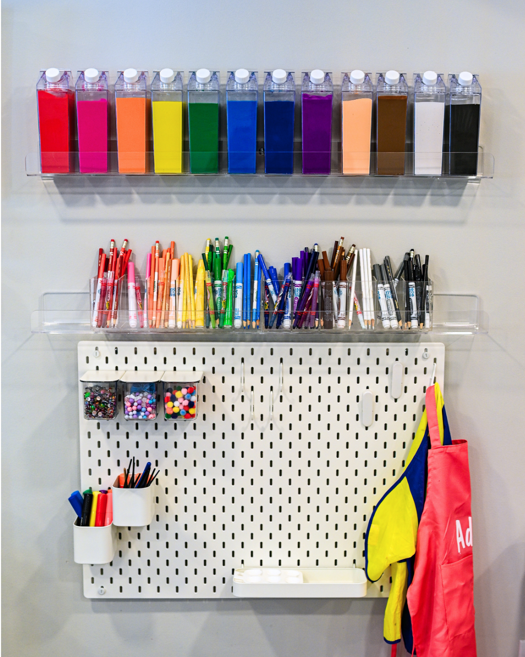 Two white plastic storage units with multiple drawers filled with LEGO pieces, placed side by side against a wall.