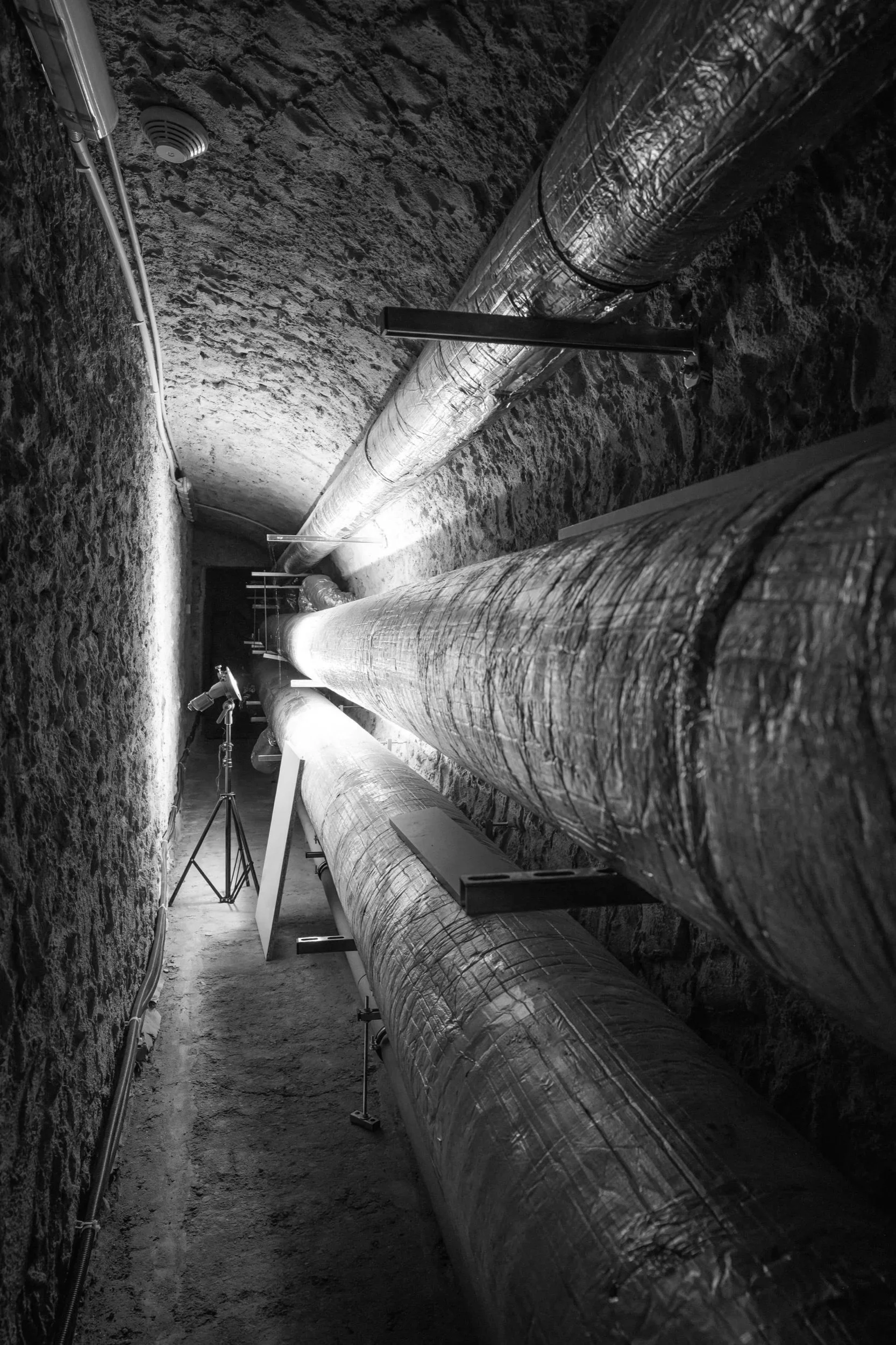 An underground duct for ventilation, heating, and cooling systems beneath a historic building