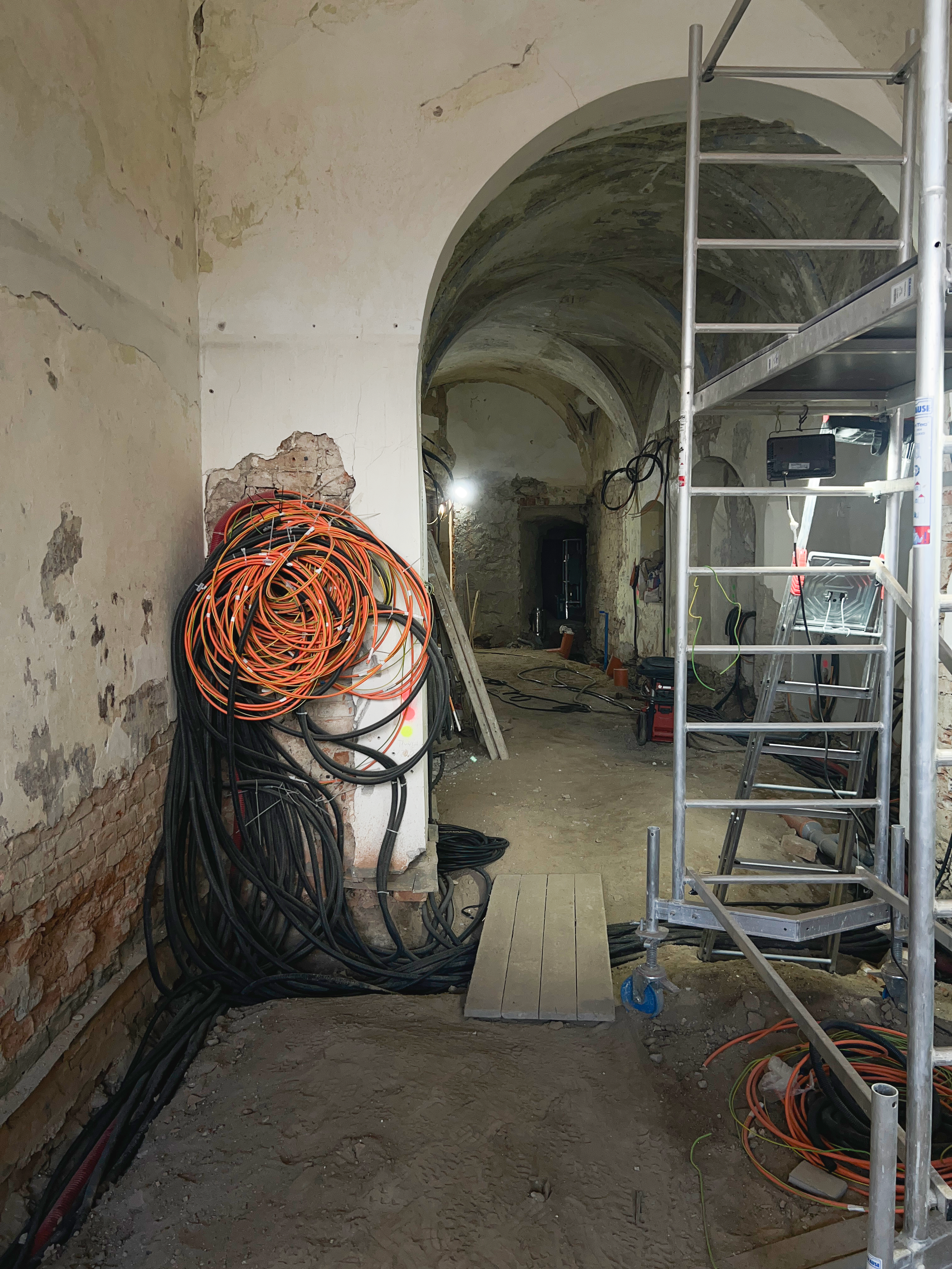 Coils of cable and scaffolding in the historic room during construction