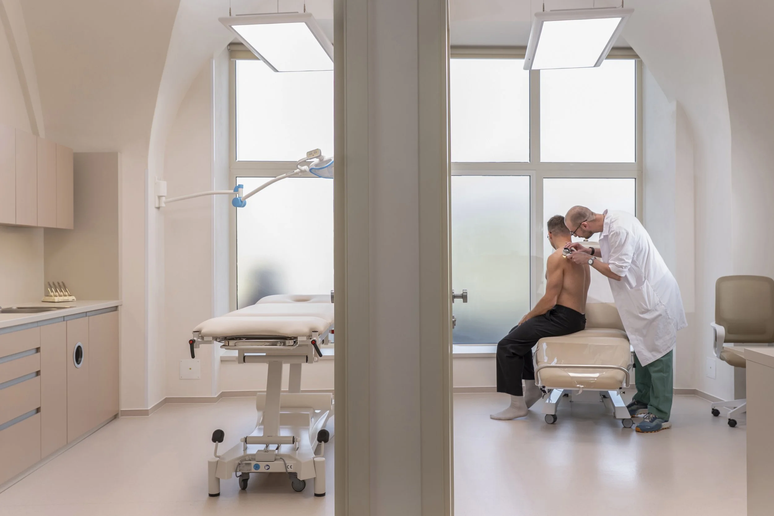 A dermatology office with natural light, examination chairs, and custom-made furniture