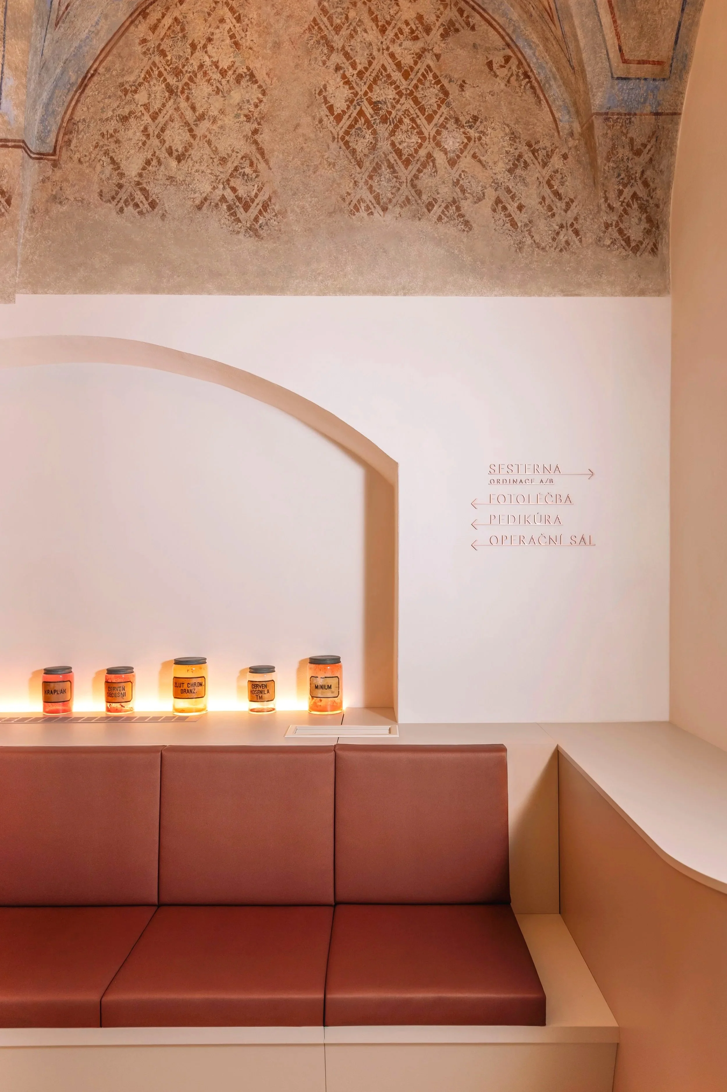 A lounge with an alcove and a custom-made upholstered bench beneath a Renaissance vaulted ceiling
