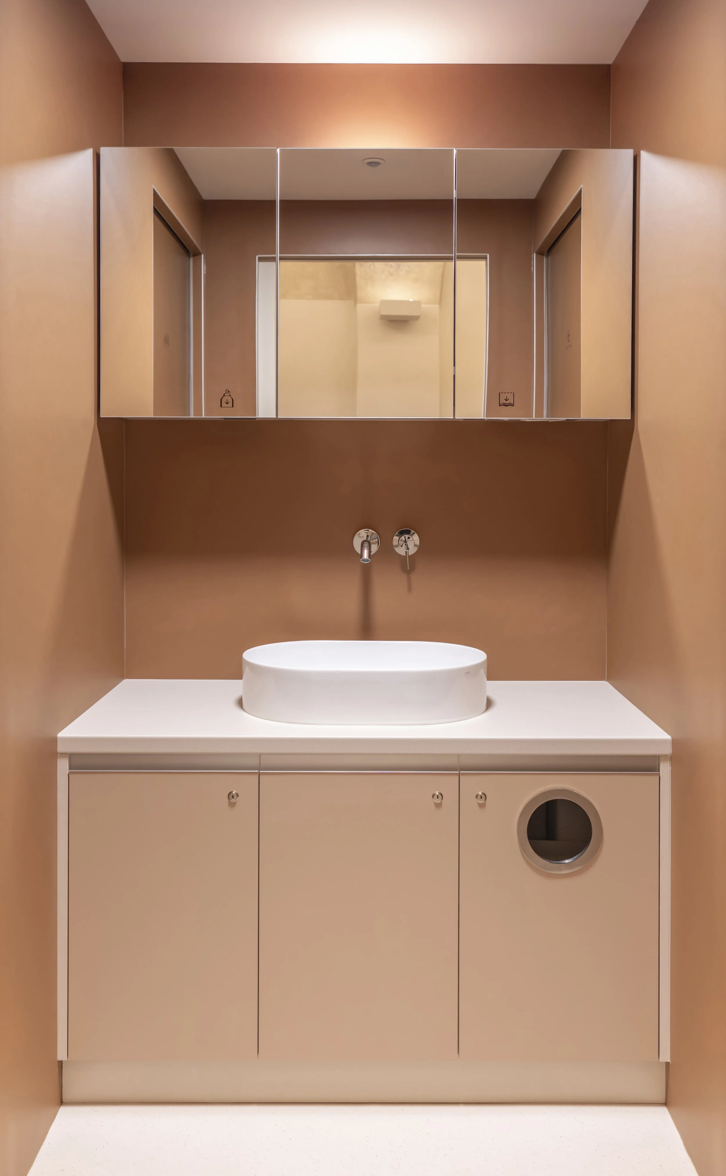 Bathroom featuring earthy tones and a custom-made mirrored cabinet