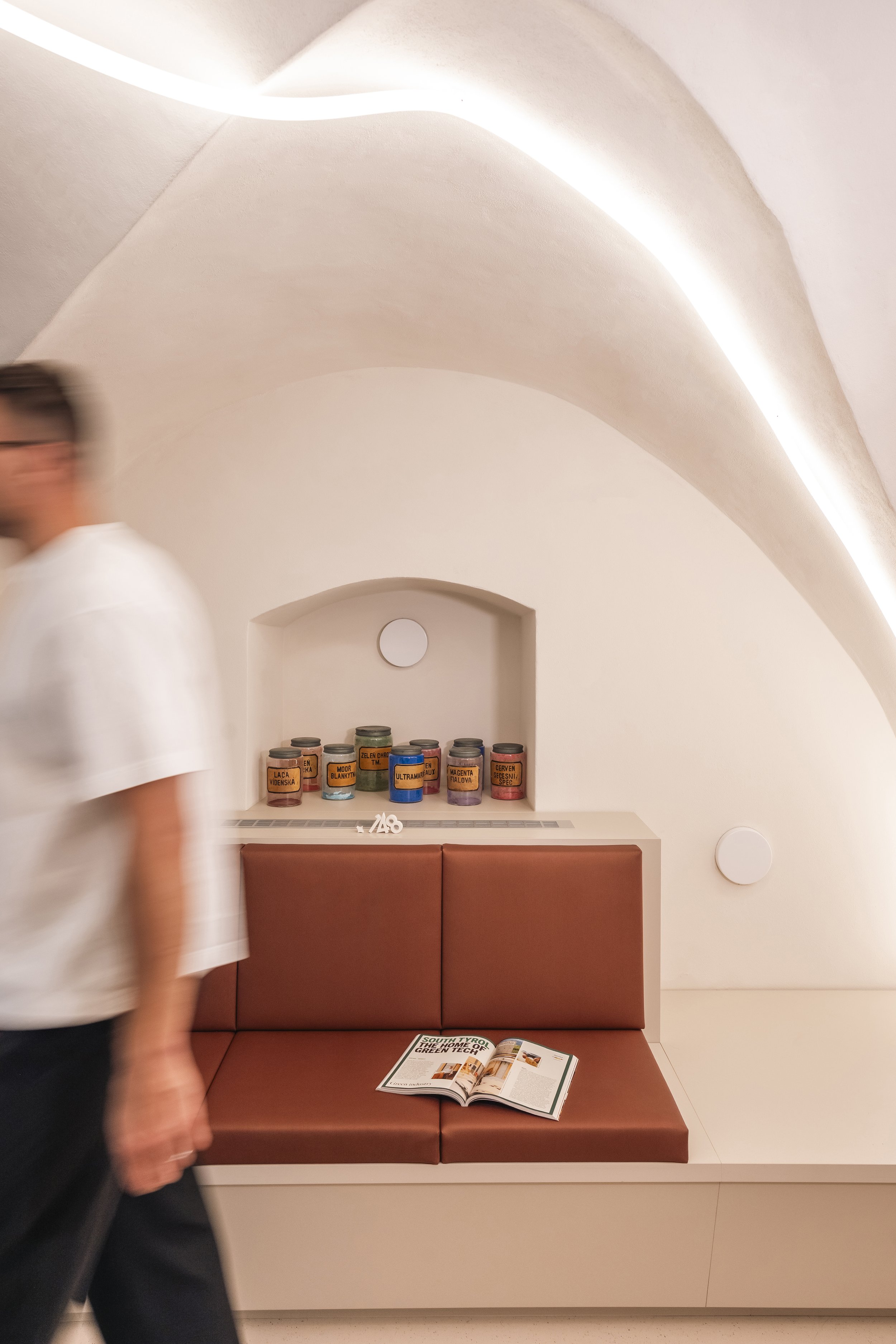 A waiting room with an upholstered bench and a niche under the vaulted ceiling