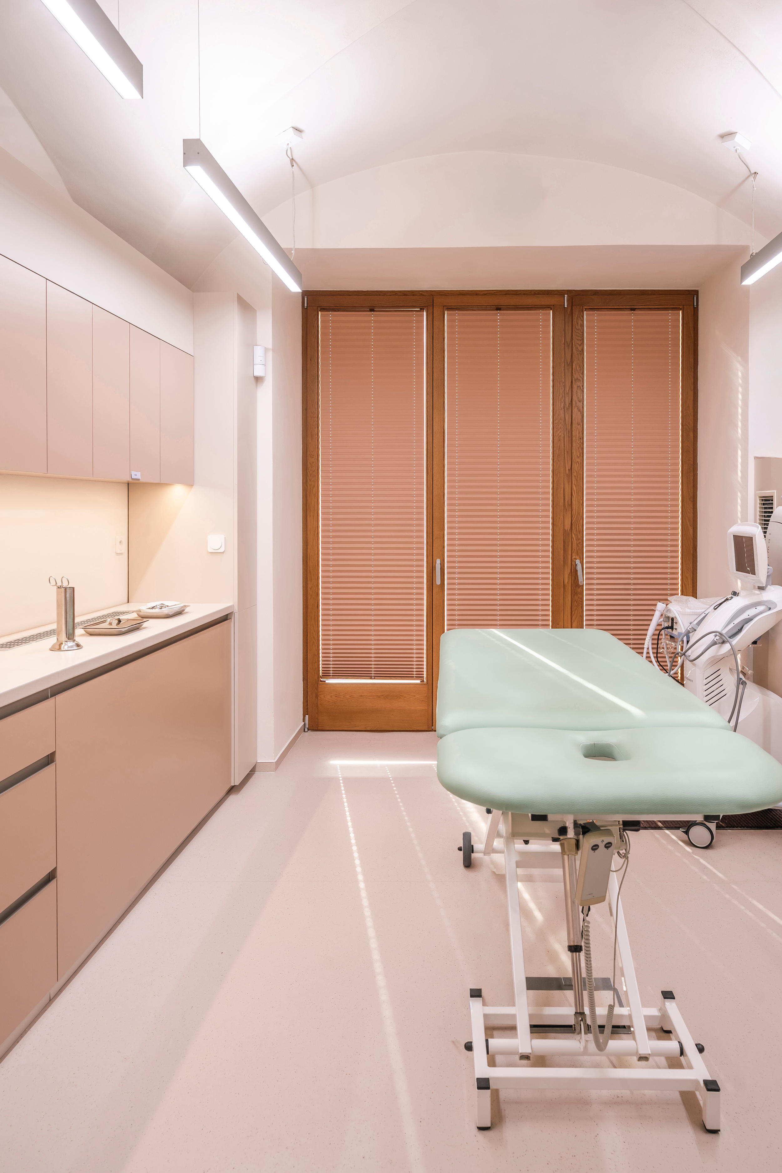 The same room after renovation: a procedure room with a treatment table under the vaulted ceiling