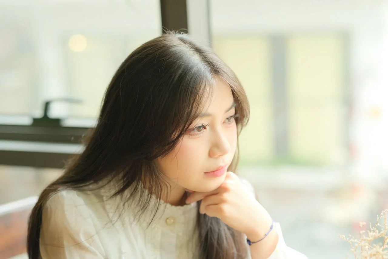 thoughtful-woman-looking-out-a-window-indoors