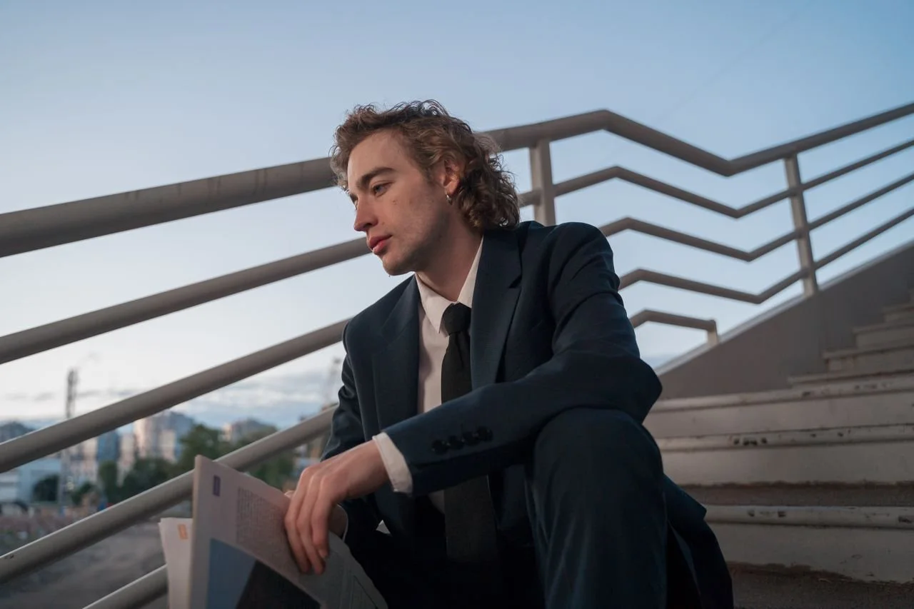 photo-of-a-man-in-a-blue-suit-sitting-on-the-stairs
