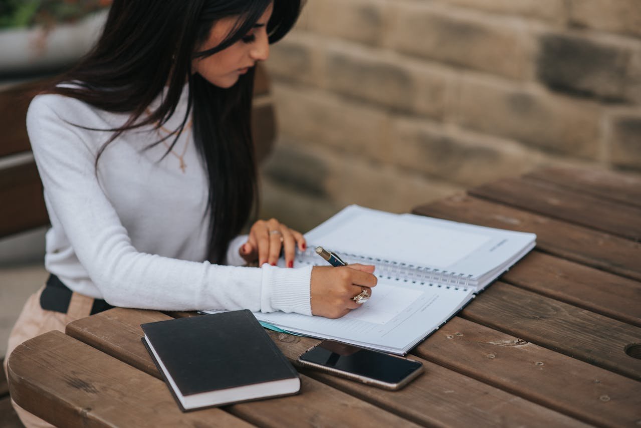 writing-in-notebook-at-street-table