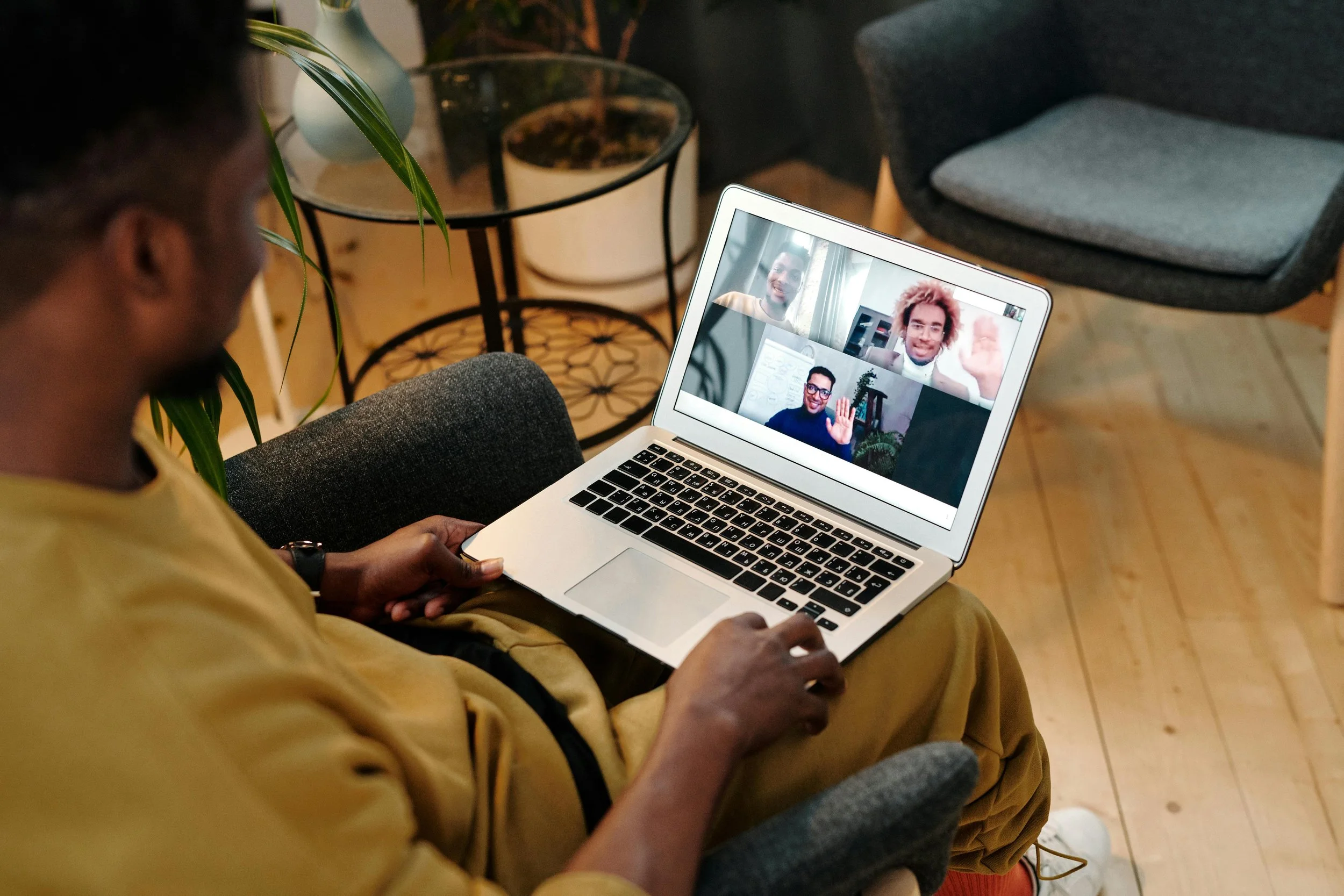 man on laptop viewing screen showing a zoom call with multiple other men