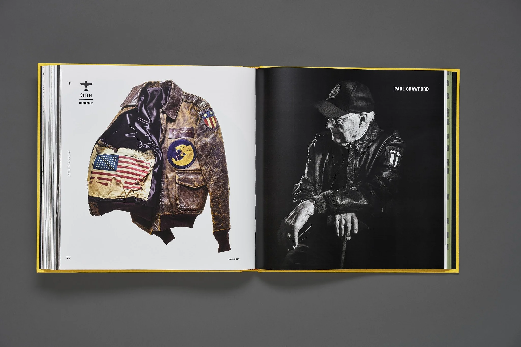 Open book showing a brown leather A-2 "bomber jacket" with patches on the left page and a black-and-white portrait of P-51 Mustang pilot Paul Crawford on the right page.