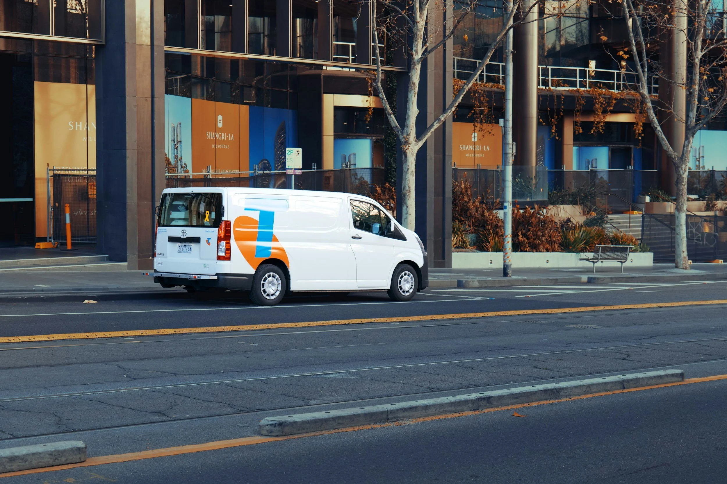 A white commercial electric vehicle driving on the road after being charged by RoadZap ev charging.