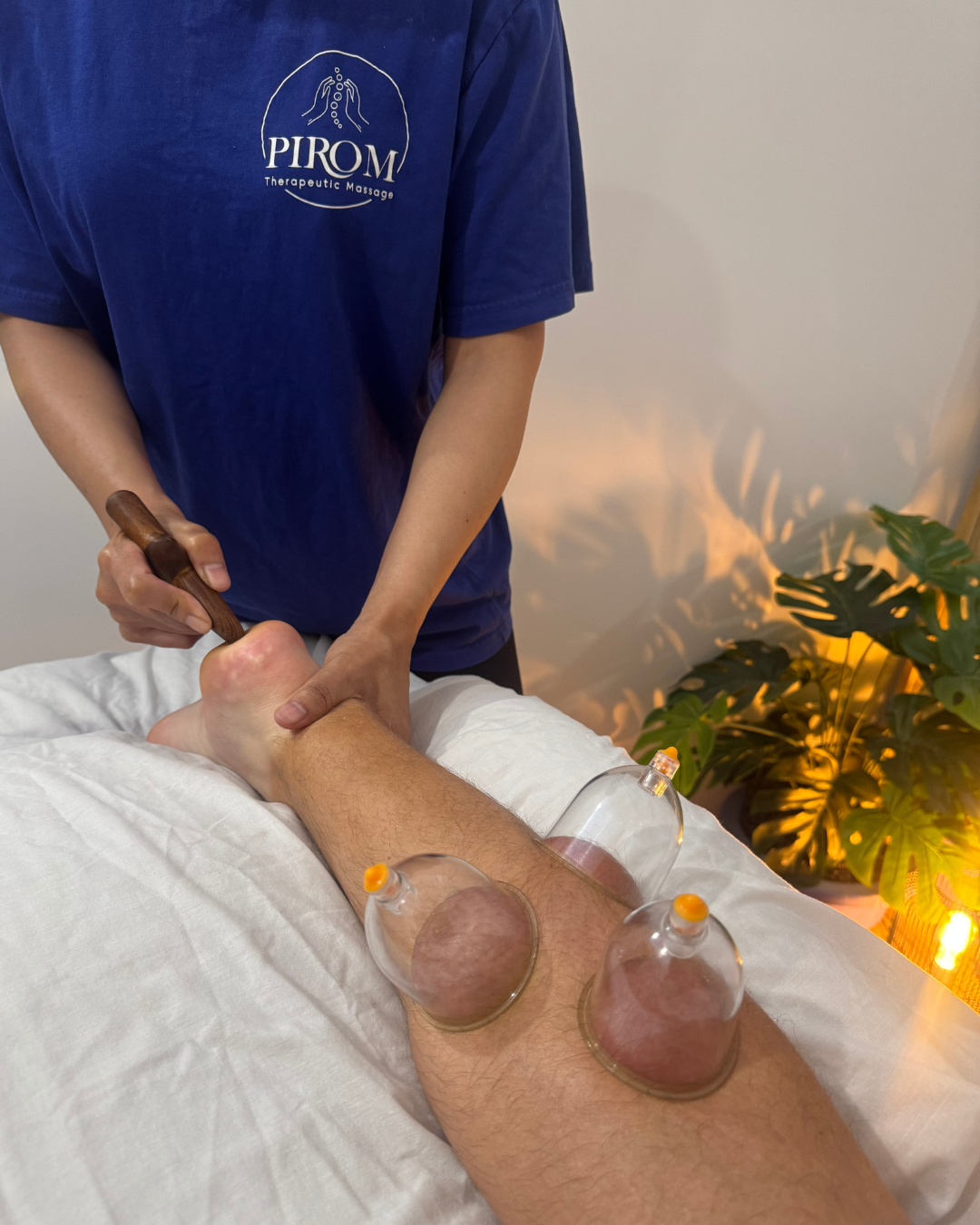 Sports therapeutic massage using cupping therapy and instrument-assisted soft tissue techniques on the lower leg during a Pirom Reset treatment at Pirom Therapeutic Massage in New Zealand.