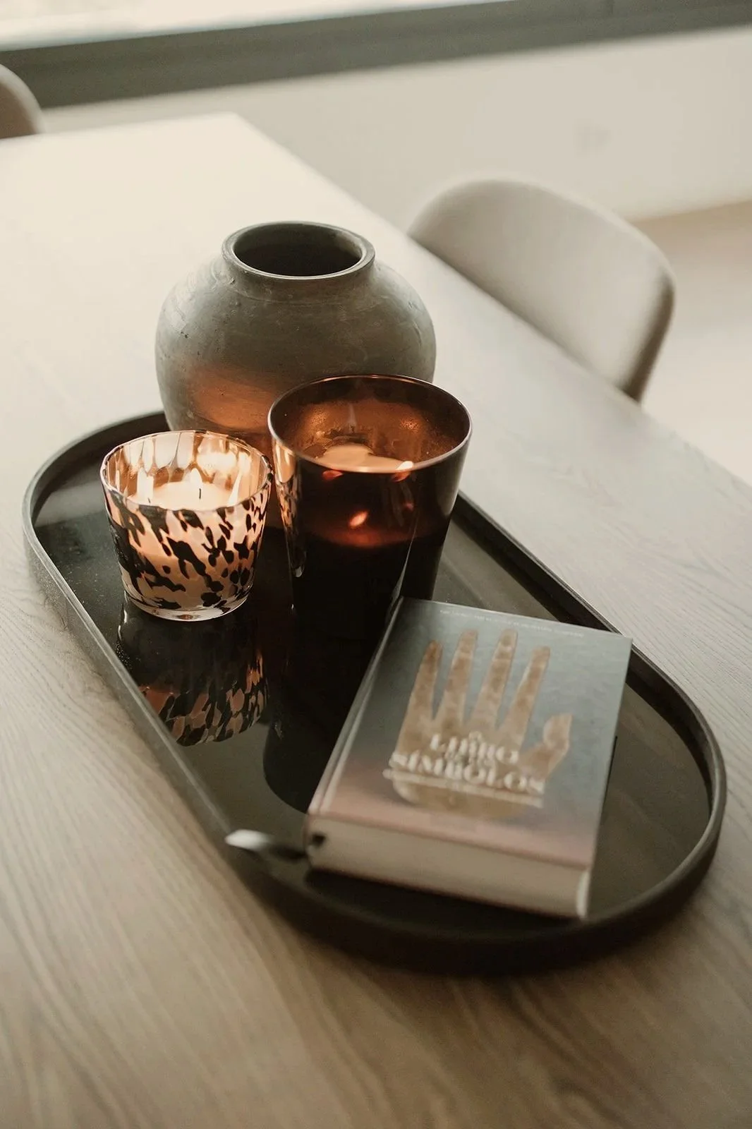 Porta velas, vaso y jarra en bandeja sobre mesa de madera clara