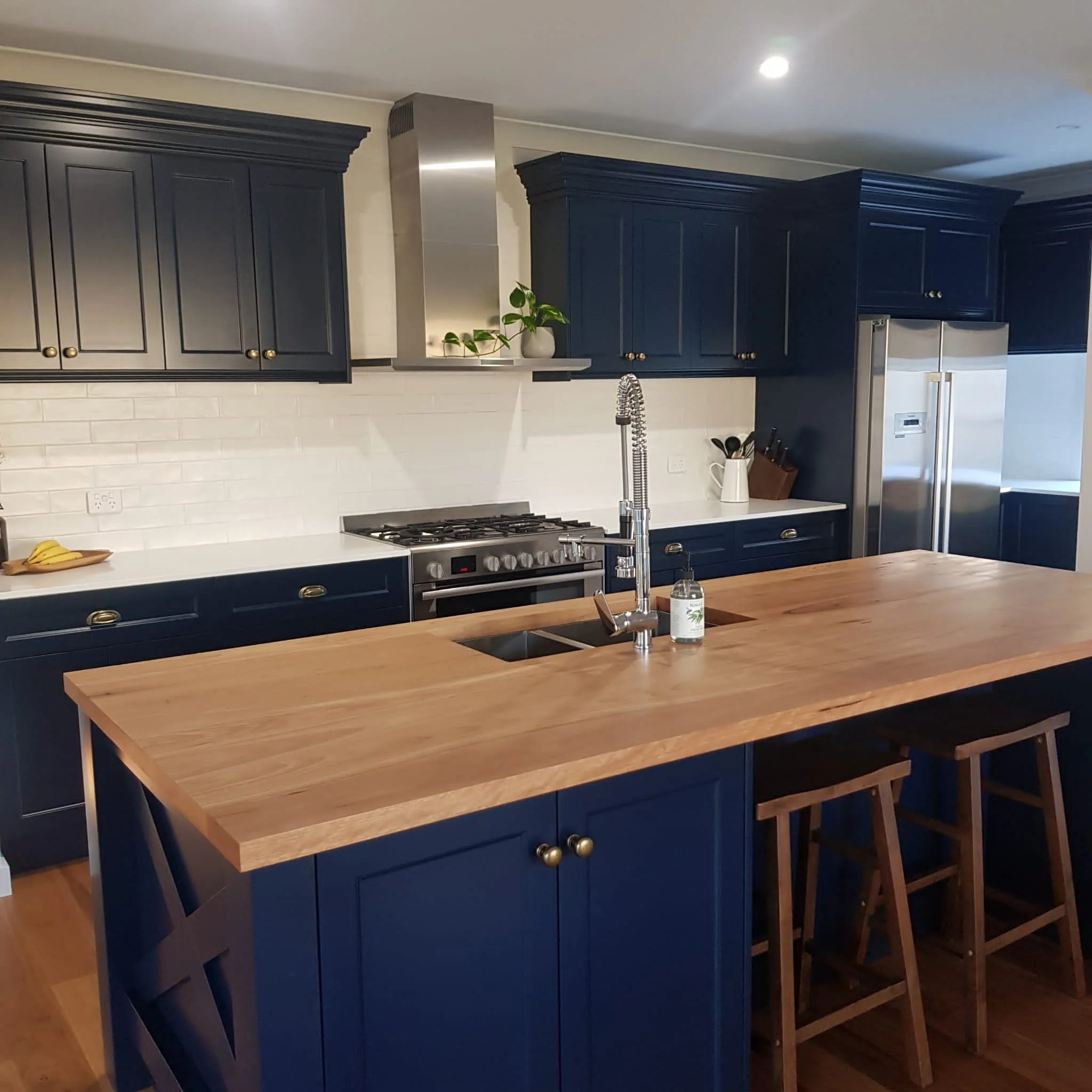 Wooden countertop and navy blue painted cabinets