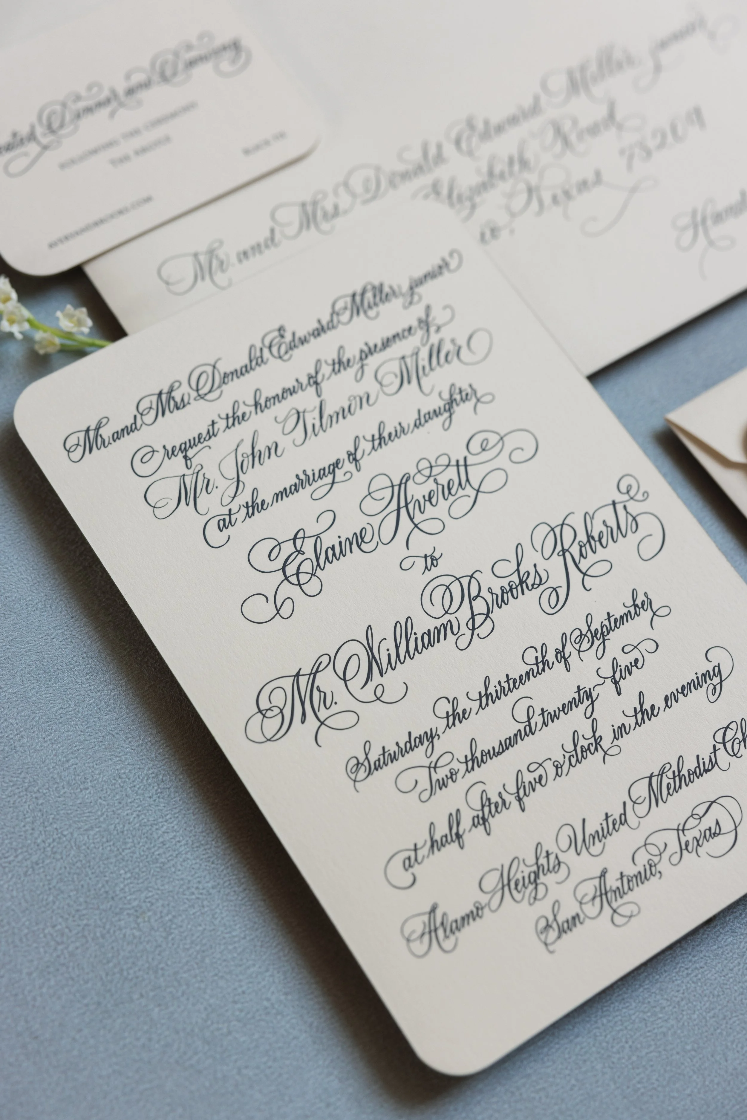 Wedding invitation with elegant black calligraphy script, engraved.