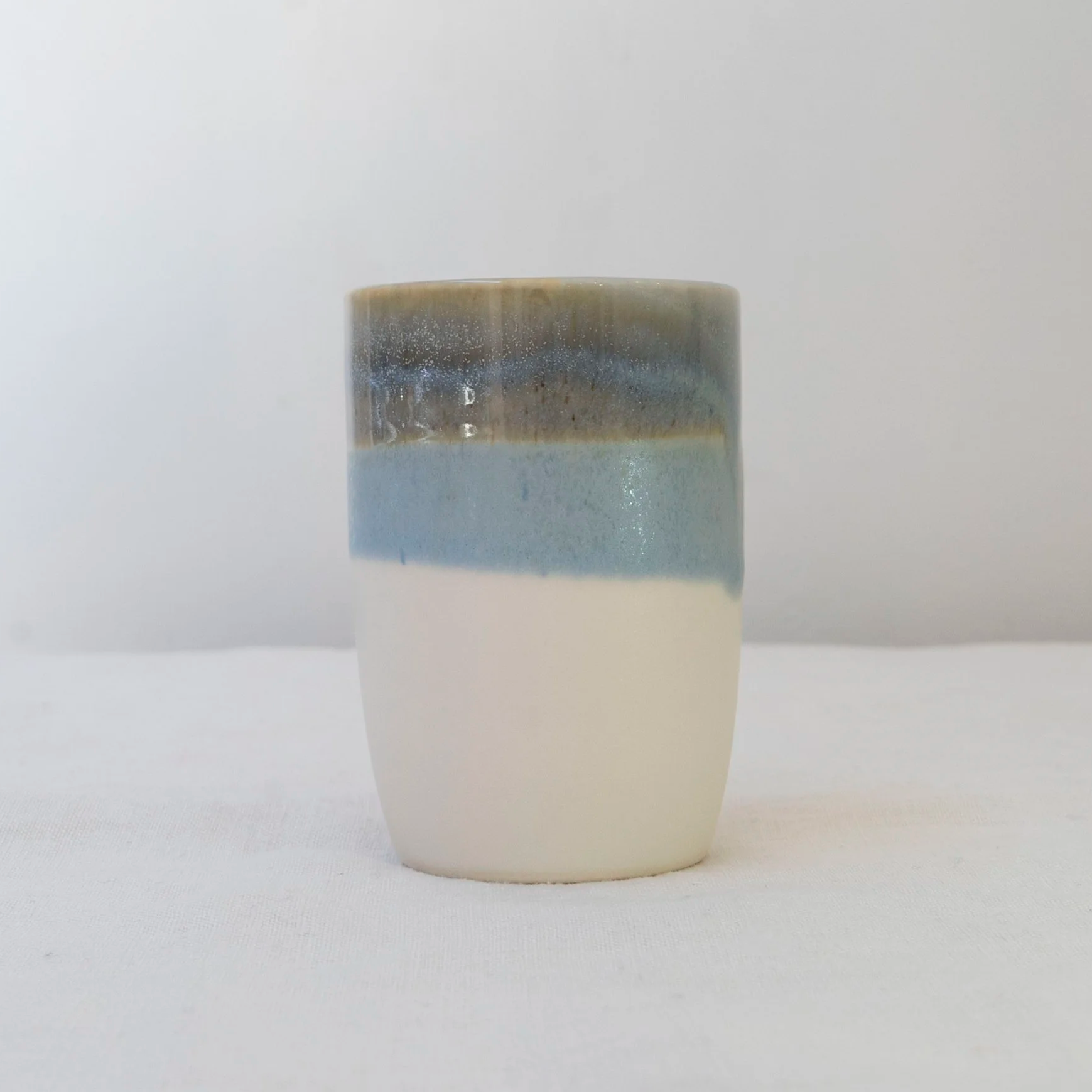 Handmade blue and white stoneware cup with layered glaze by Desvio Ceramics