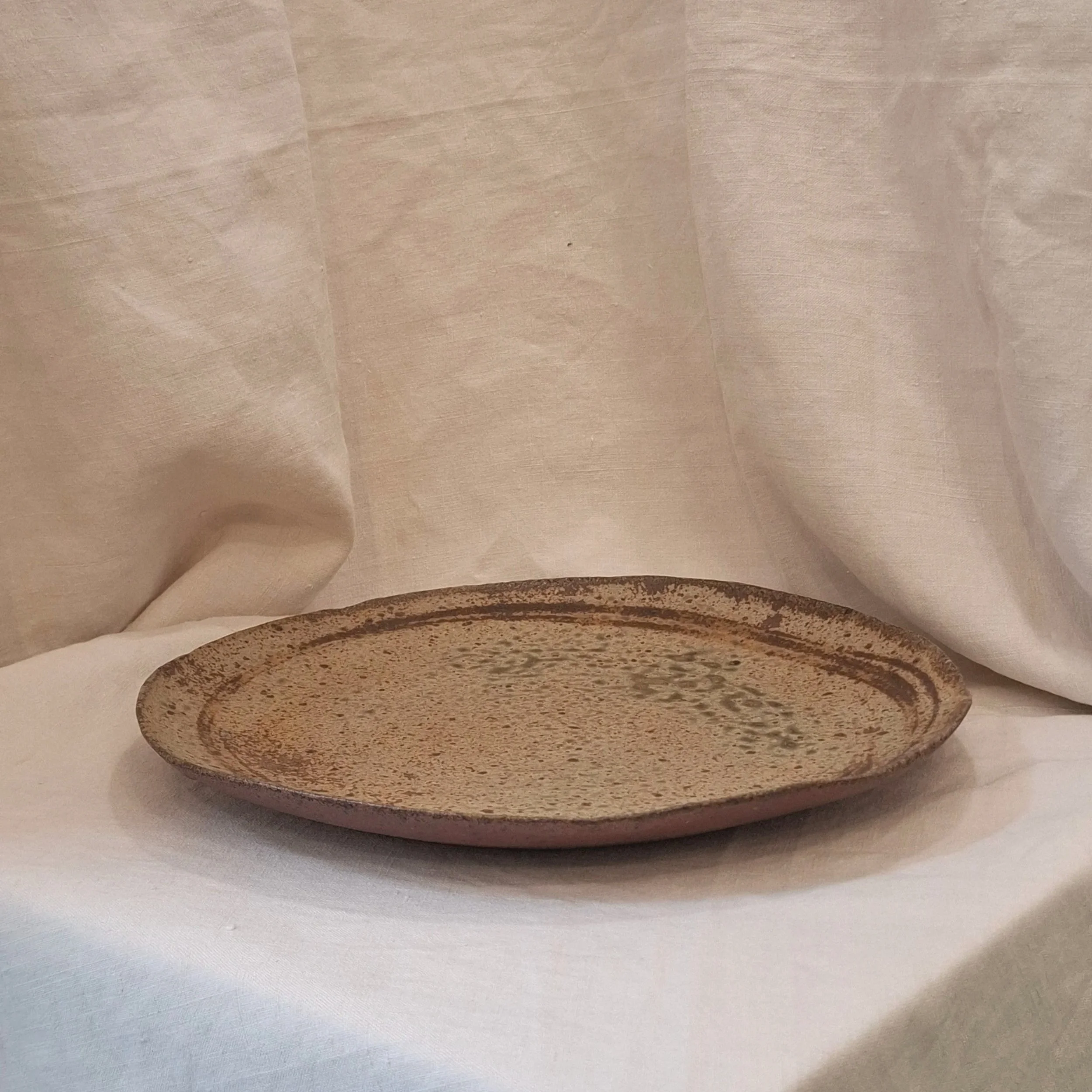 Green speckled glazed stoneware plate by Miguel Neto