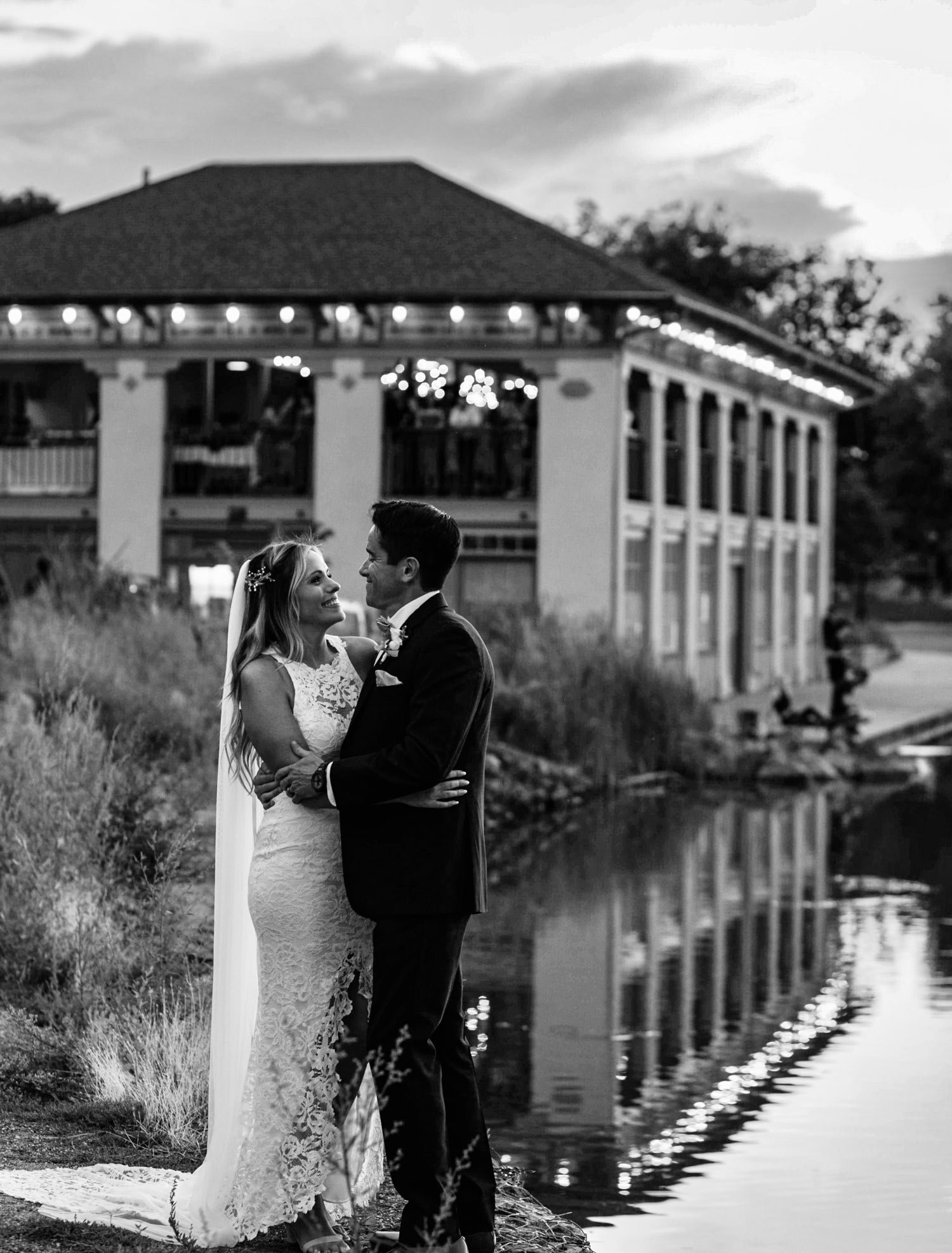 Gina Fidler and her husband kiss in front of the boathouse at Wash Park on their wedding day | Wash Park Health | Simple, Convenient, Personalized Healthcare in Wash Park, Denver