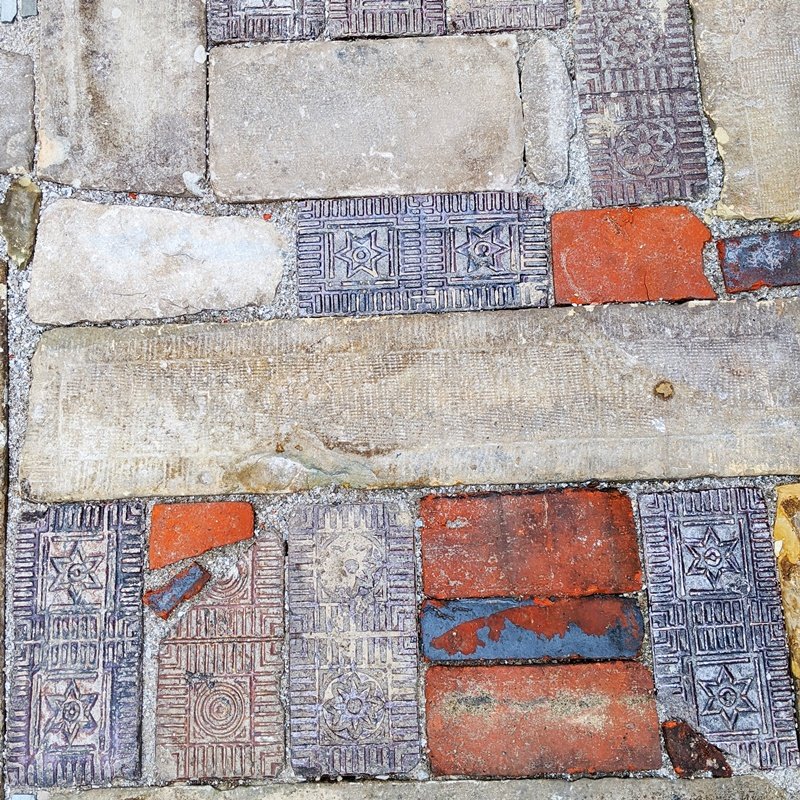 A close-up view of the old patterned brick, old red brick, and odd pieces of flat stone fitted together
