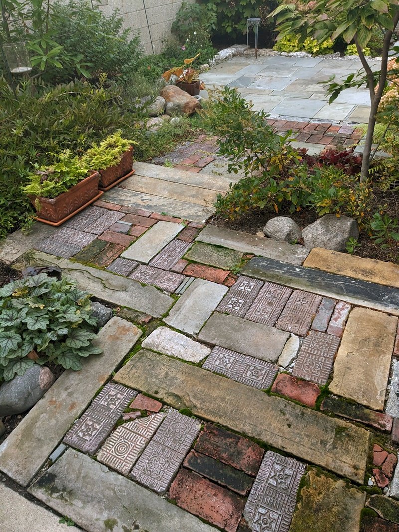 A close-up of brick and limestone and other odd pieces of stone and materials all fitting together like a puzzle to form a zigzagging path