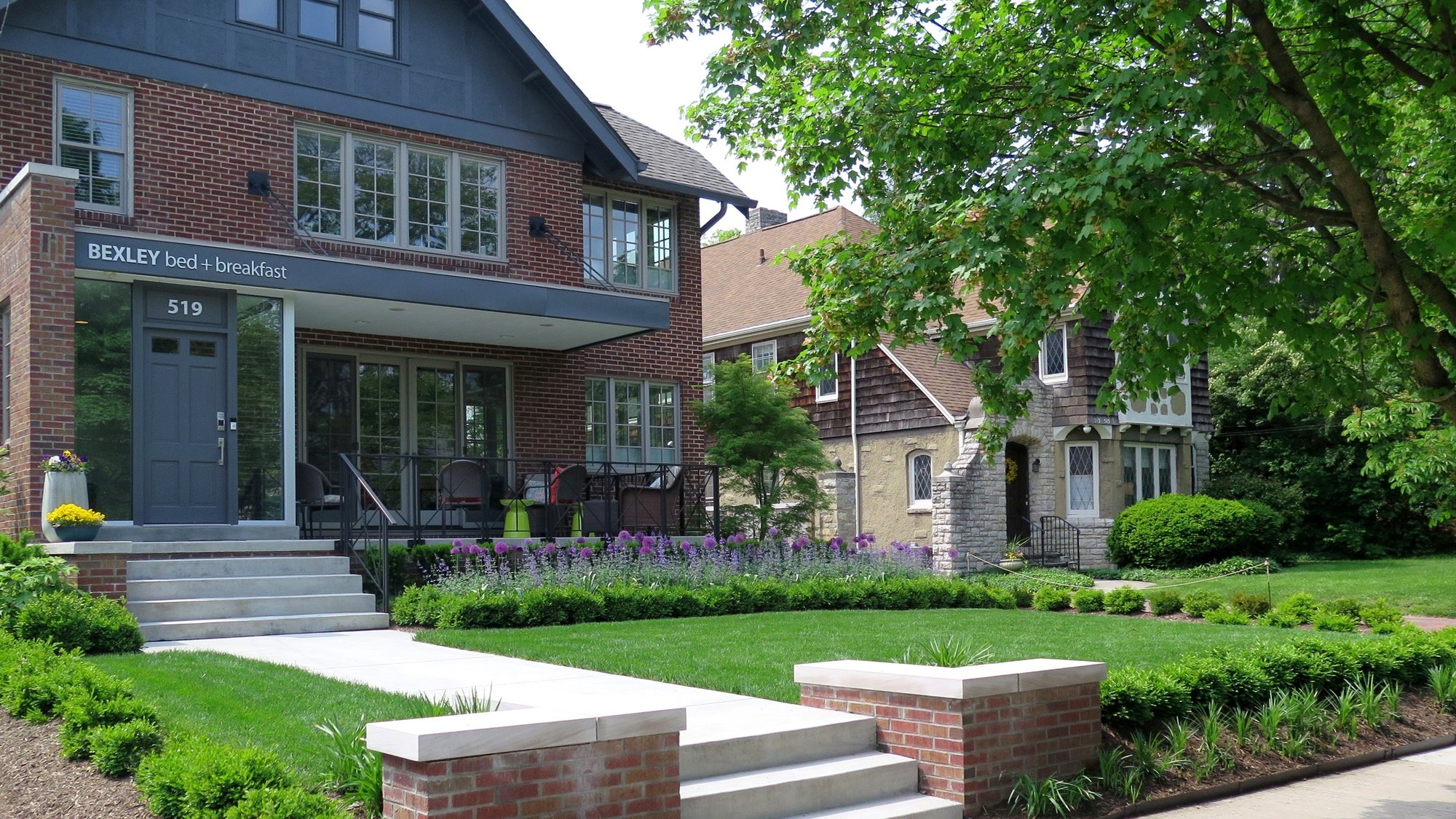 Low plantings tidily frame the slightly raised flat lawn in front of the contemporary brick and gray trim building