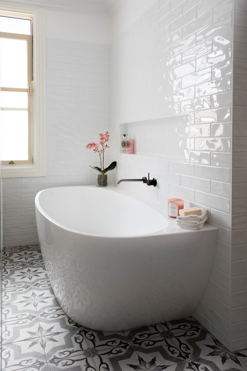 Freestanding bath with black tap wear on black and white tiles. Interior design by Marilena Baynes, Brisbane.