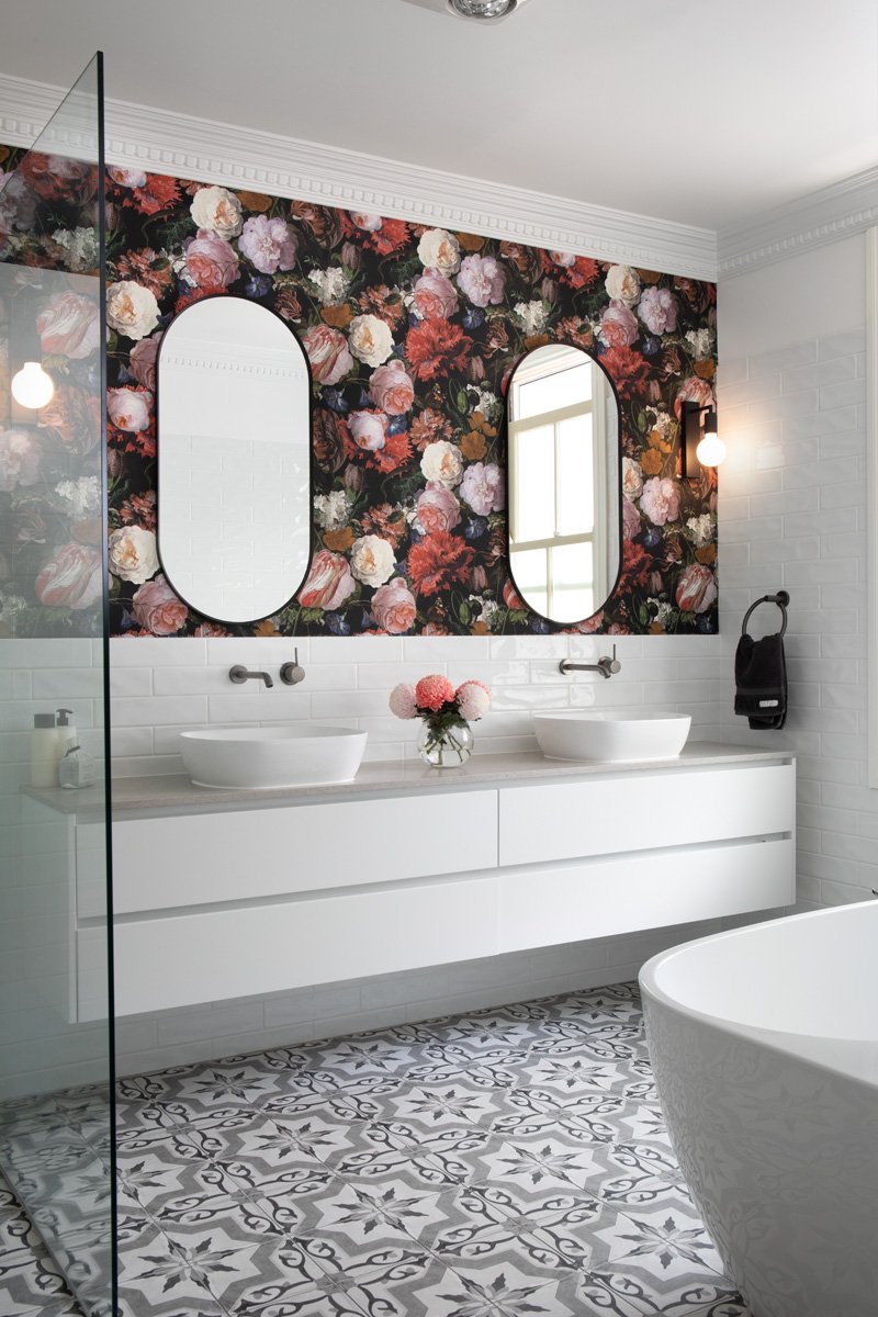 Side view of striking floral wallpaper used as a backdrop to a double vanity of a Morningside interior design bathroom project by Marilena Baynes