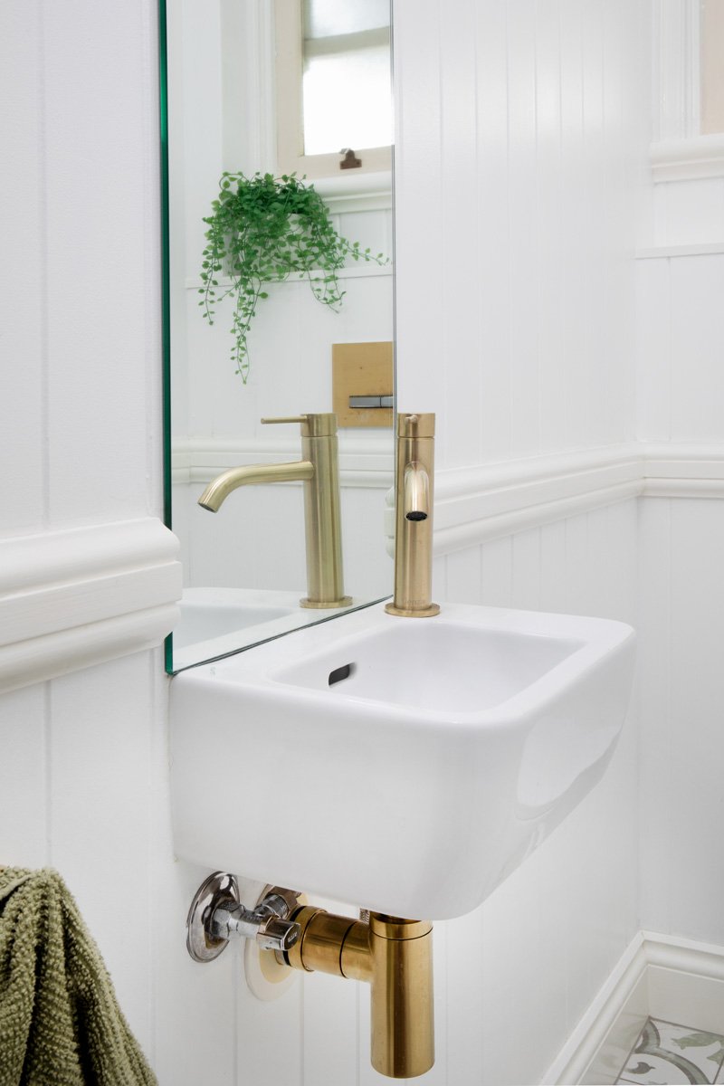 Small space vanity with gold tap fittings in this Morningside interior design project by Marilena Baynes