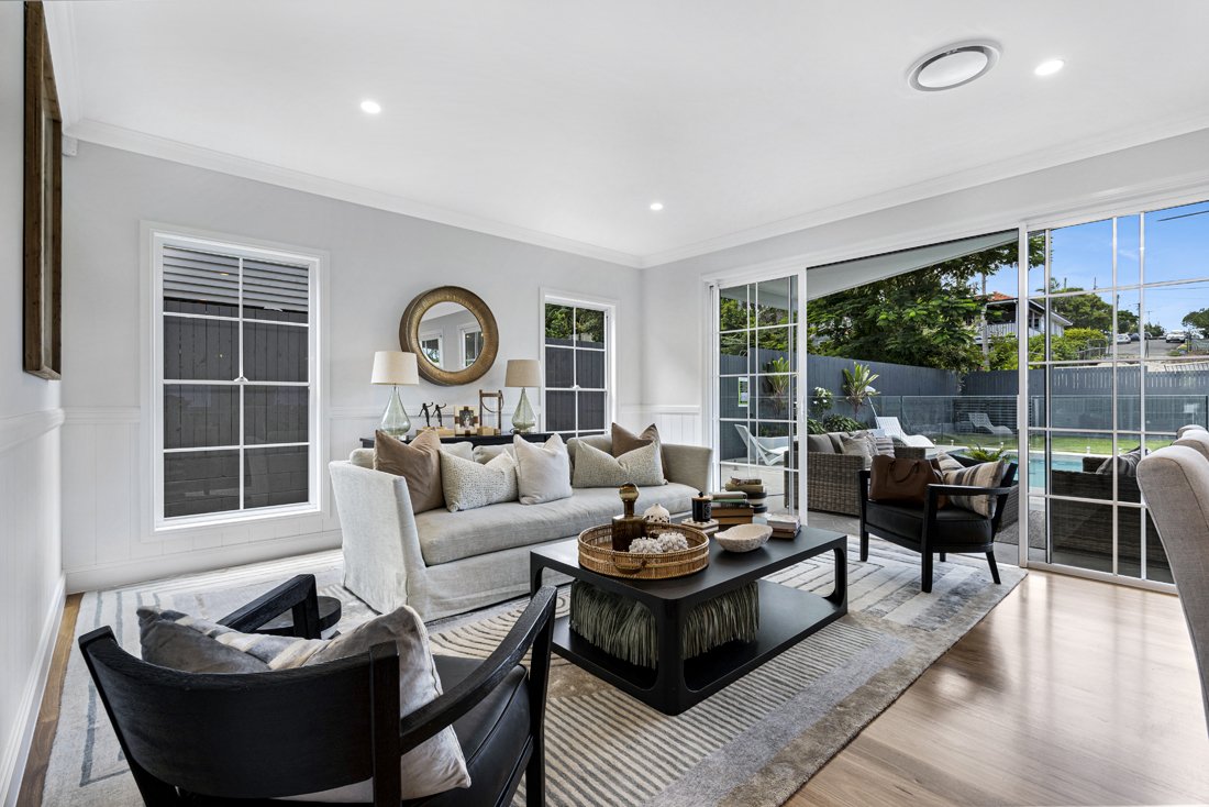 Living space with fully open doors and floor rugs in this Wavell Heights home.